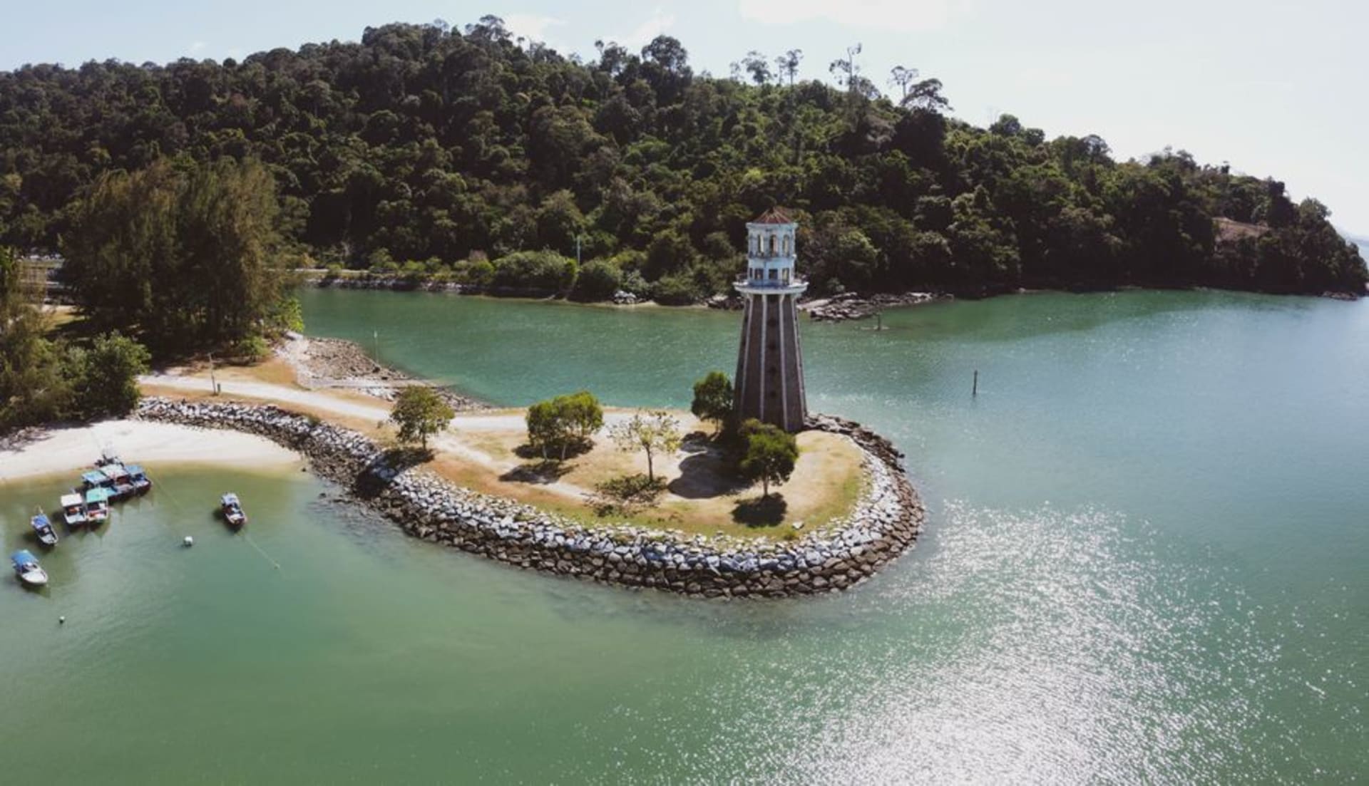 Forested coastline of Pulau Singa Besar seen from the water during an island-hopping boat tour