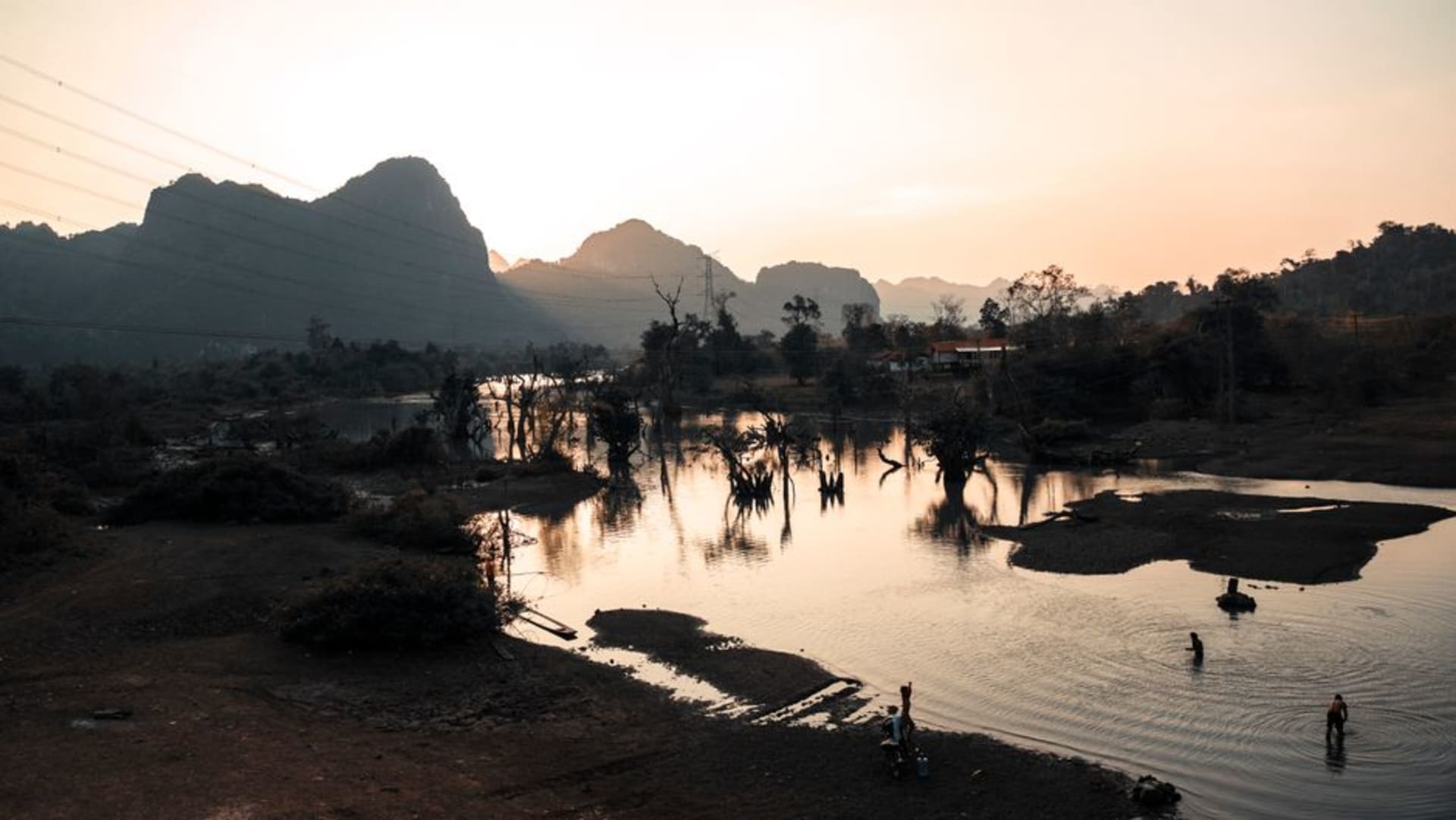 Limestone karst cliffs riddled with cave entrances at Vieng Xai, Laos