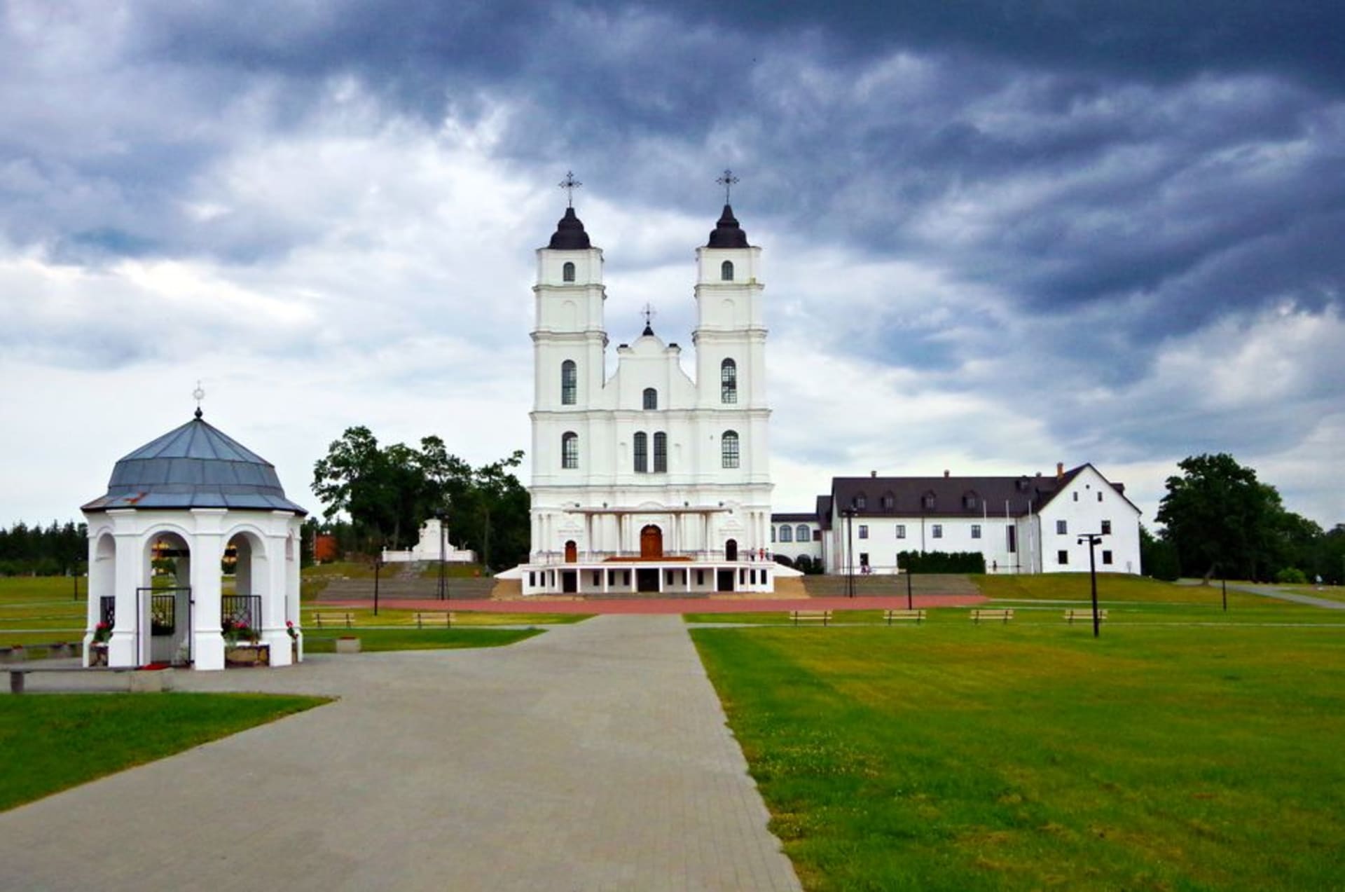 The white twin-towered Baroque facade of Aglona Basilica against a wide Latgale sky