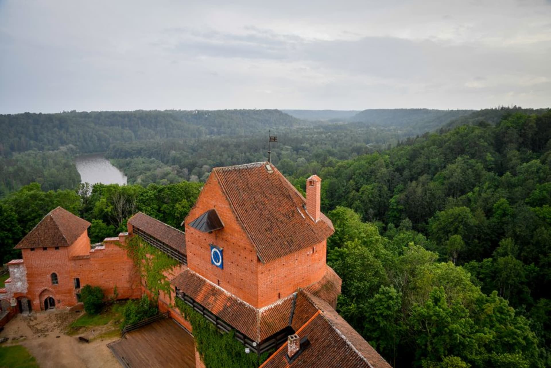 The red-brick tower of Turaida Castle rising above the forested Gauja River valley