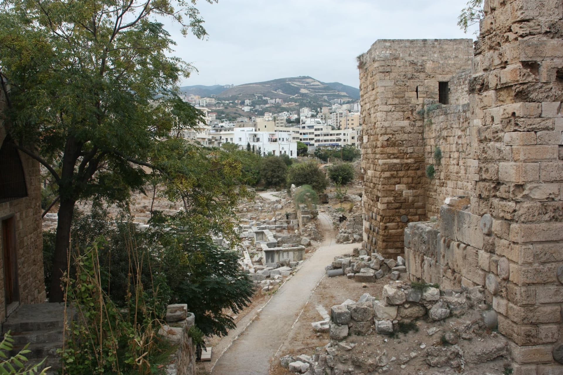 Ancient Phoenician stone ruins at Byblos standing against the modern cityscape of Lebanon