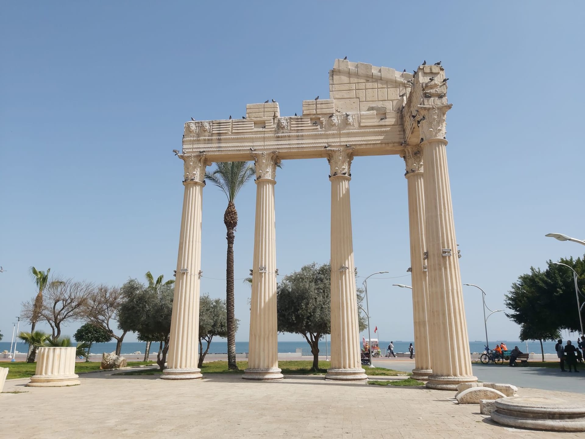 Roman colonnaded street at Tyre with ancient marble columns lining a paved road, the Mediterranean Sea visible in the background