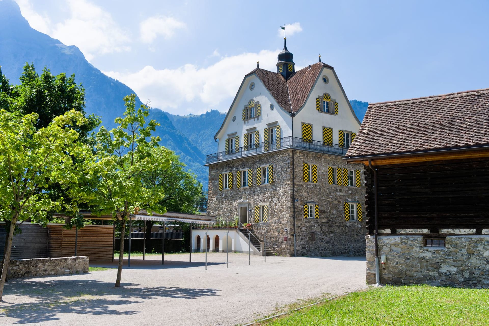 Gaflei Alpine hamlet at 1483 meters, traditional farmhouses against a backdrop of high rocky peaks and an impossibly clear blue sky