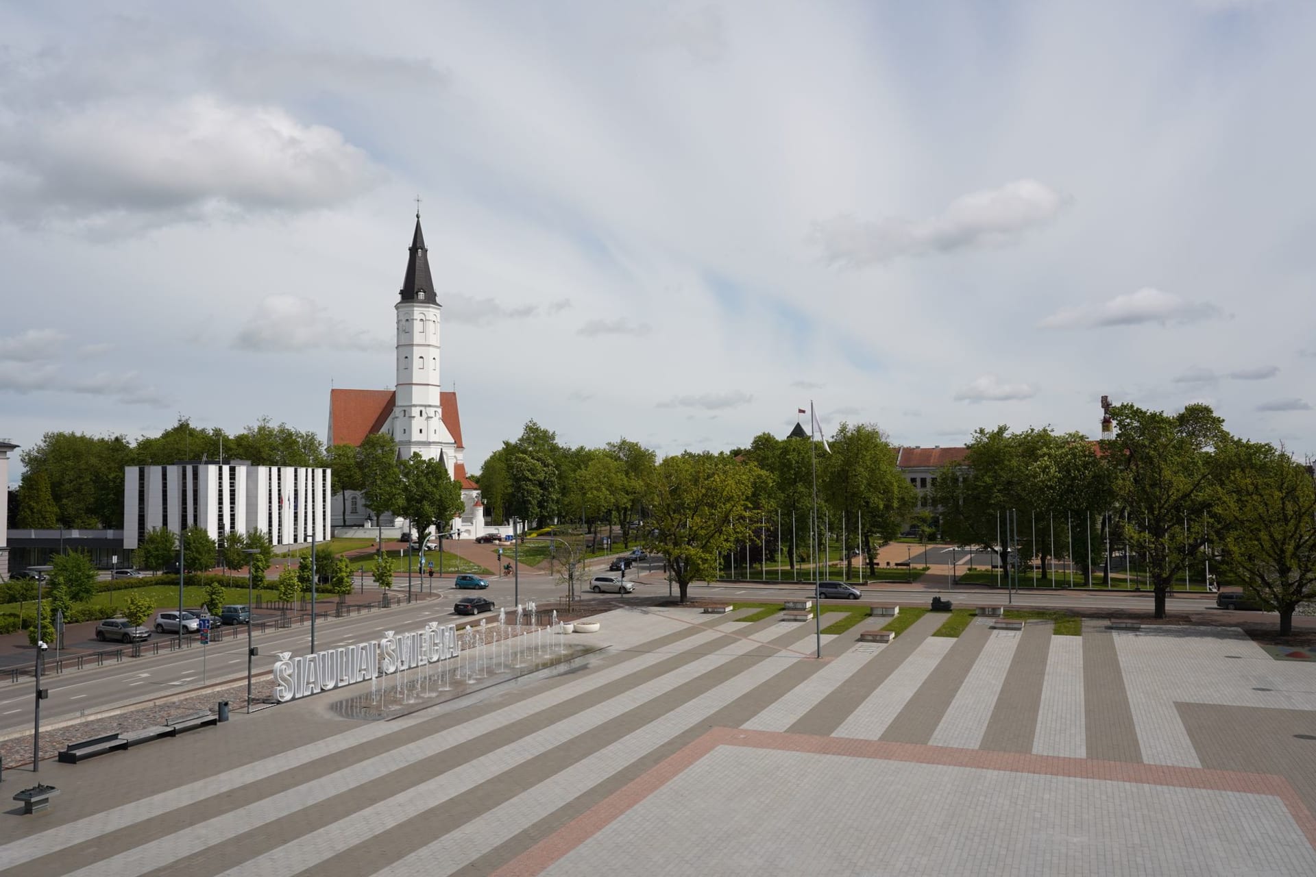 The golden angel statue of Užupis on its column at the main roundabout, surrounded by flowering trees in spring