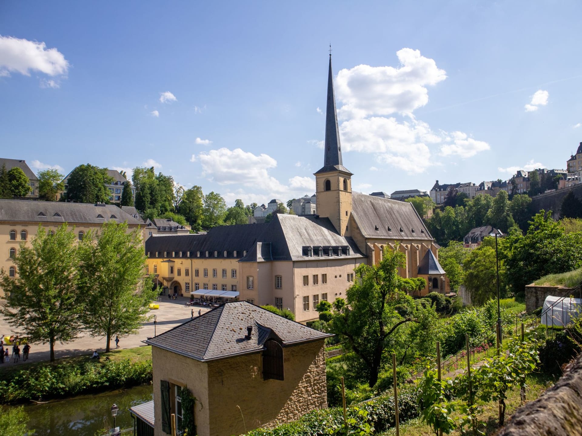 Diekirch town centre with the church tower reflected in the calm Sûre river on a still morning