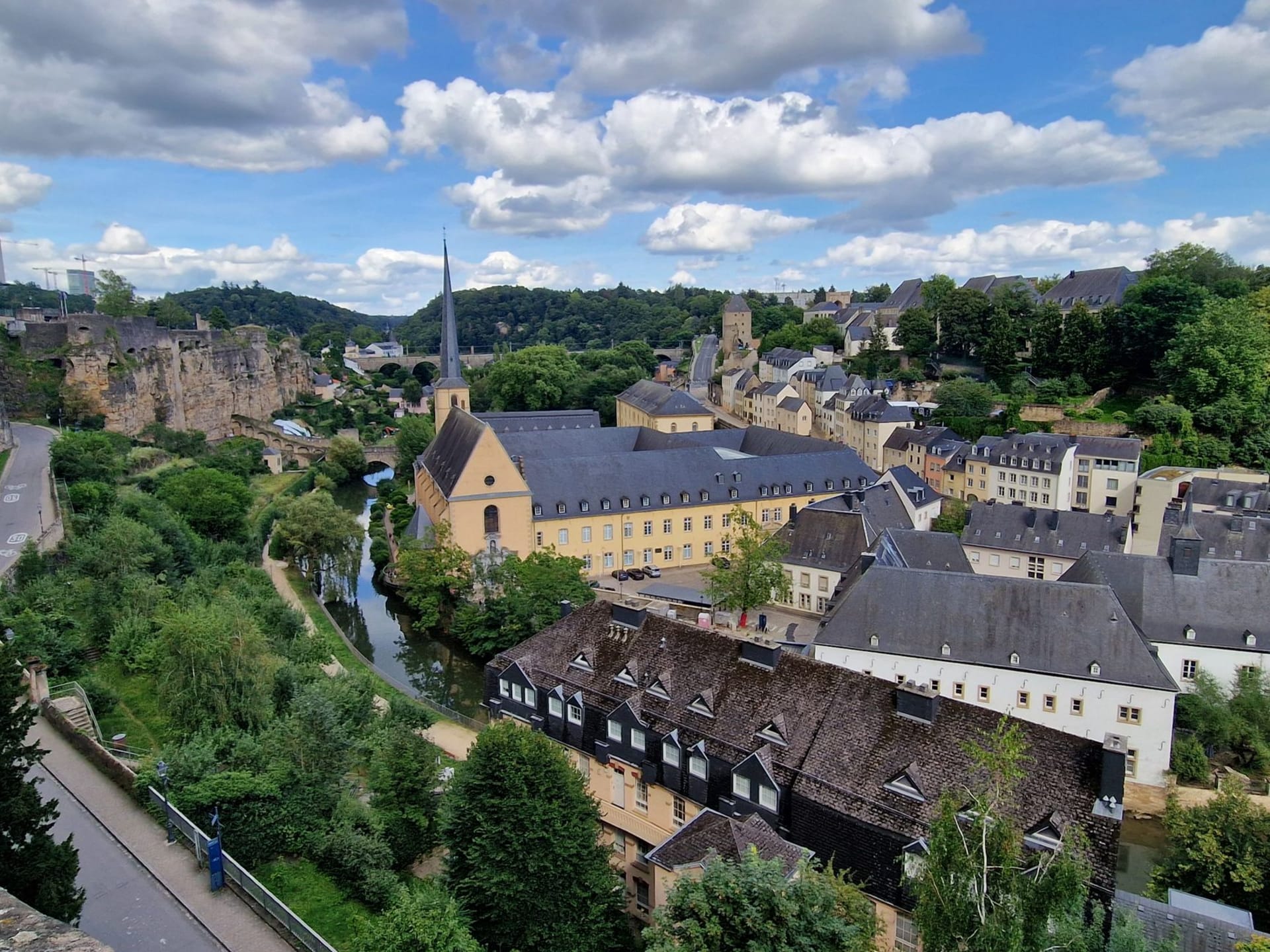 Panorámica de la ciudad de Luxemburgo con el río Alzette serpenteando por el barrio del Grund bajo los acantilados del casco antiguo, la abadía de Neumünster en primer plano