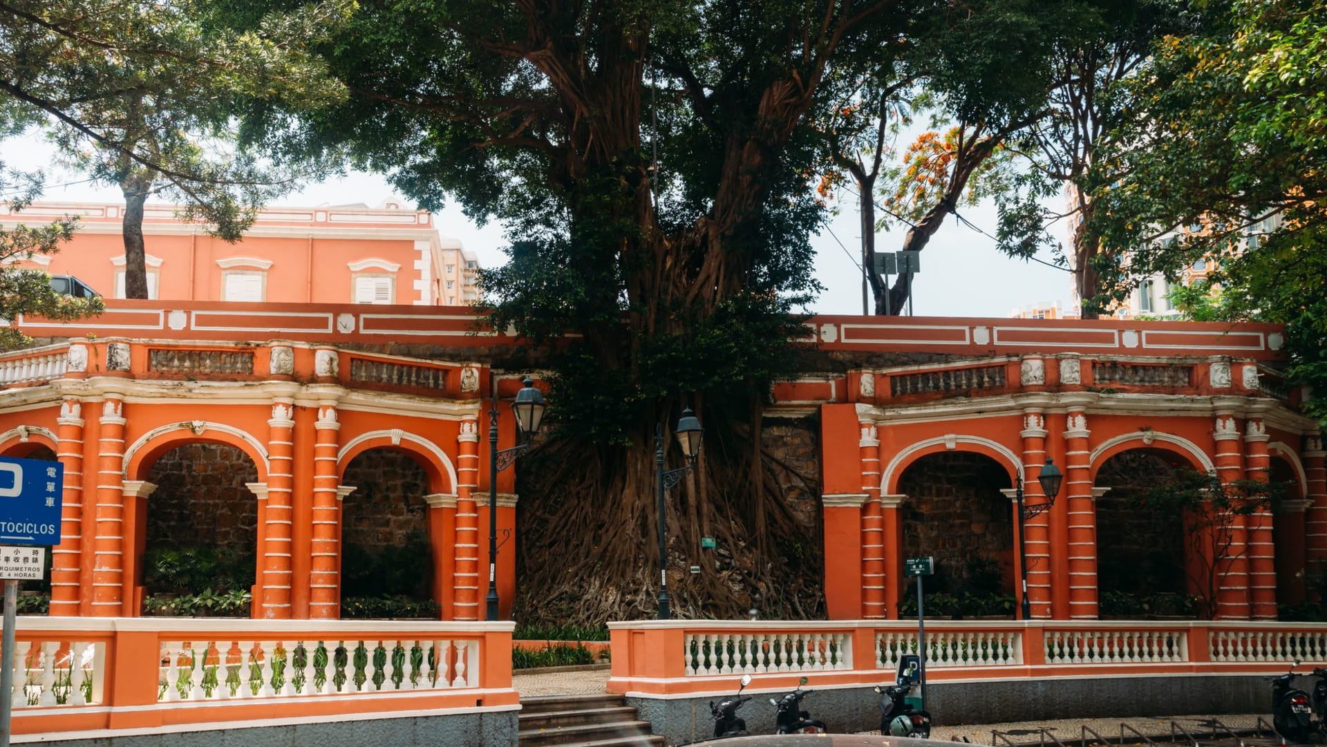 Una hilera de mansiones coloniales perfectamente conservadas en amarillo, verde y rosa a lo largo del paseo de las Casas de Taipa, con buganvillas desbordándose sobre las barandillas