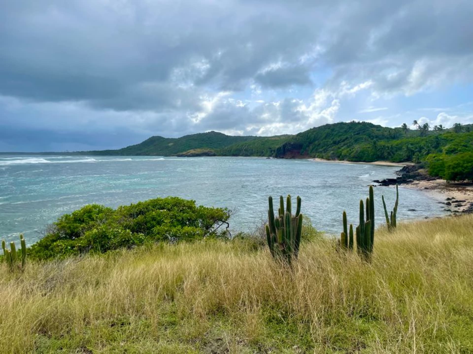 La playa de arena blanca y el agua turquesa de Sainte-Anne con barcos de pesca anclados frente a la costa