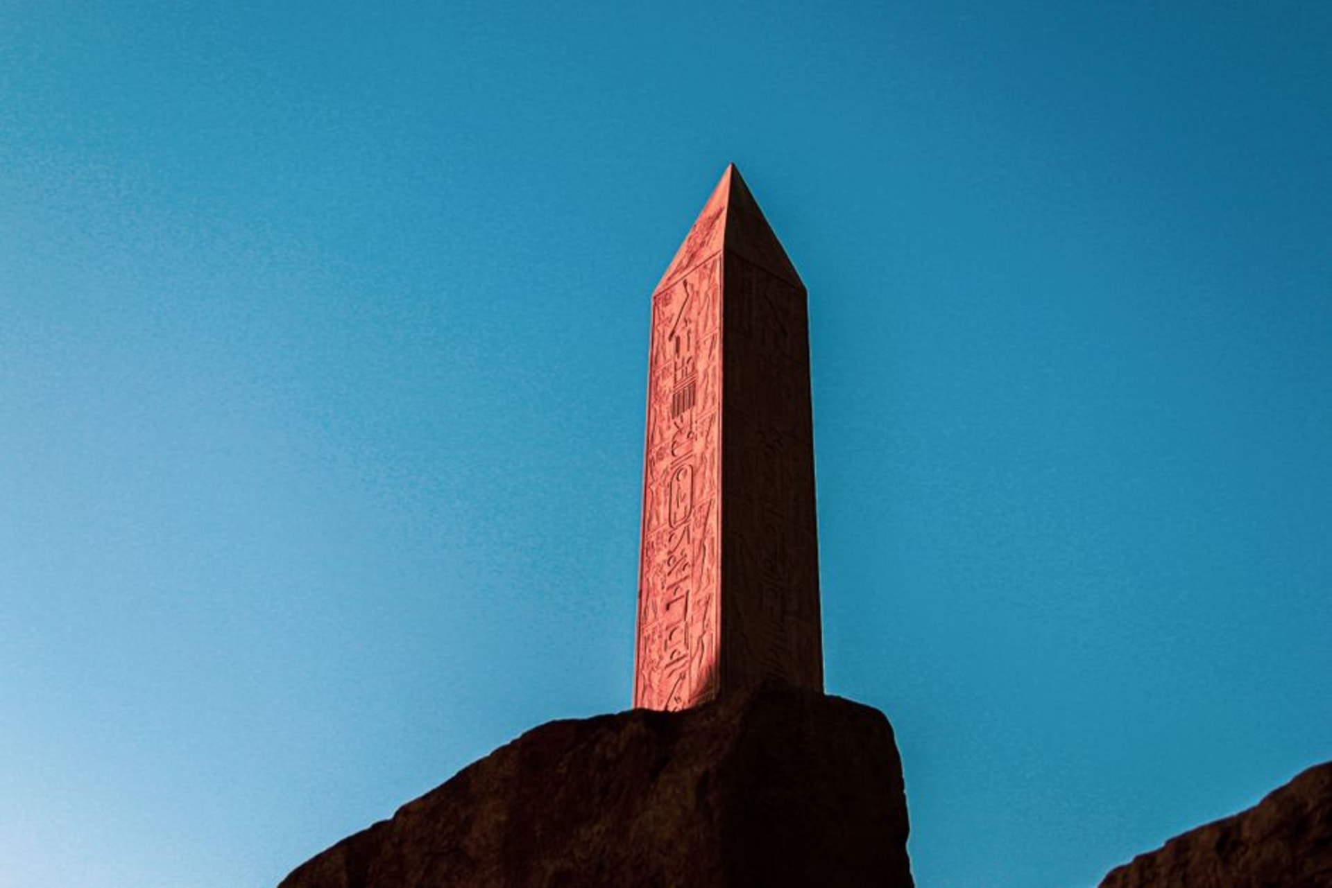 The granite monolith of Ben Amera rising from the flat Saharan desert under a pale sky