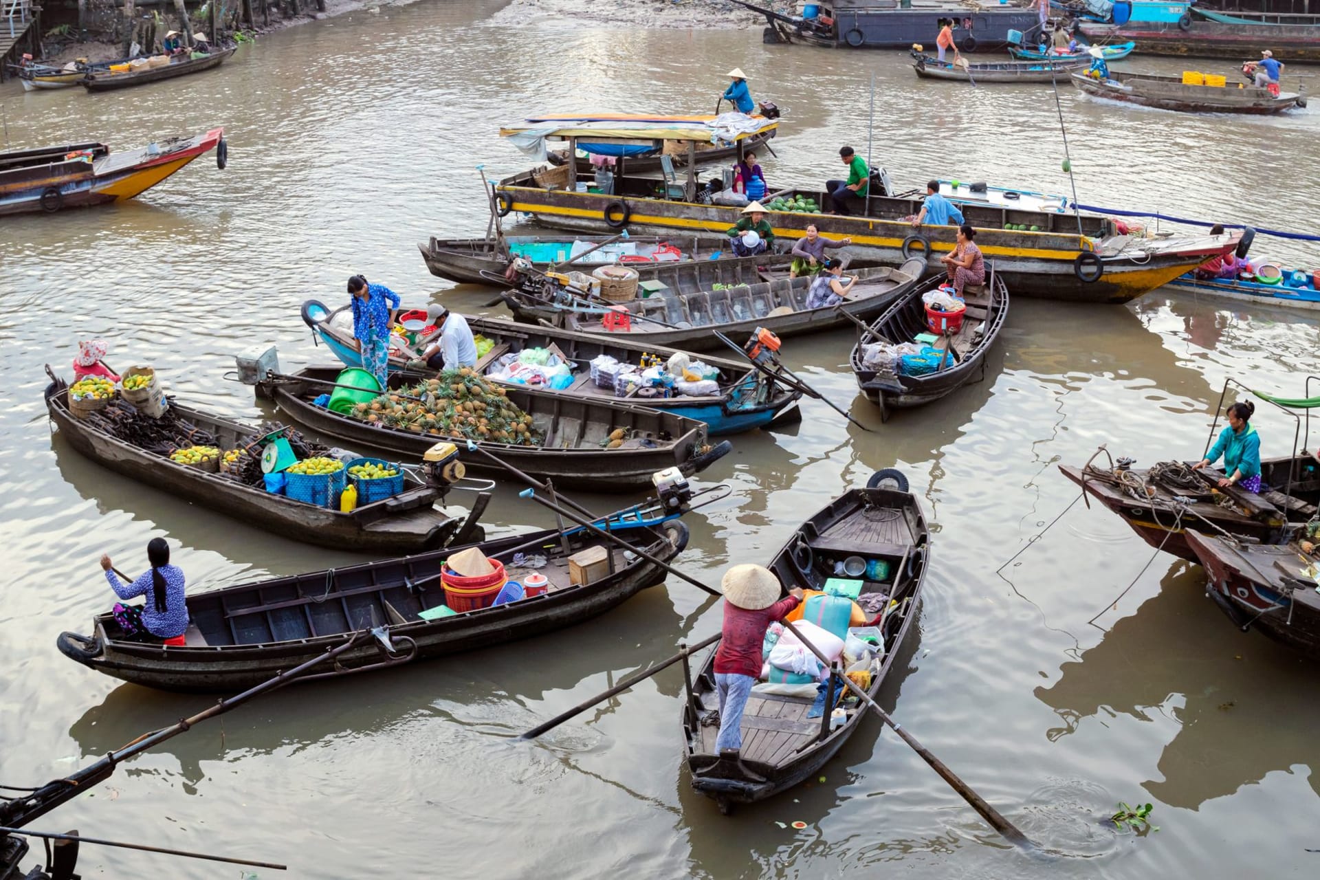 A white Cham mosque with minarets reflected in the Mekong near Chau Doc, wooden fishing boats in the foreground at dawn