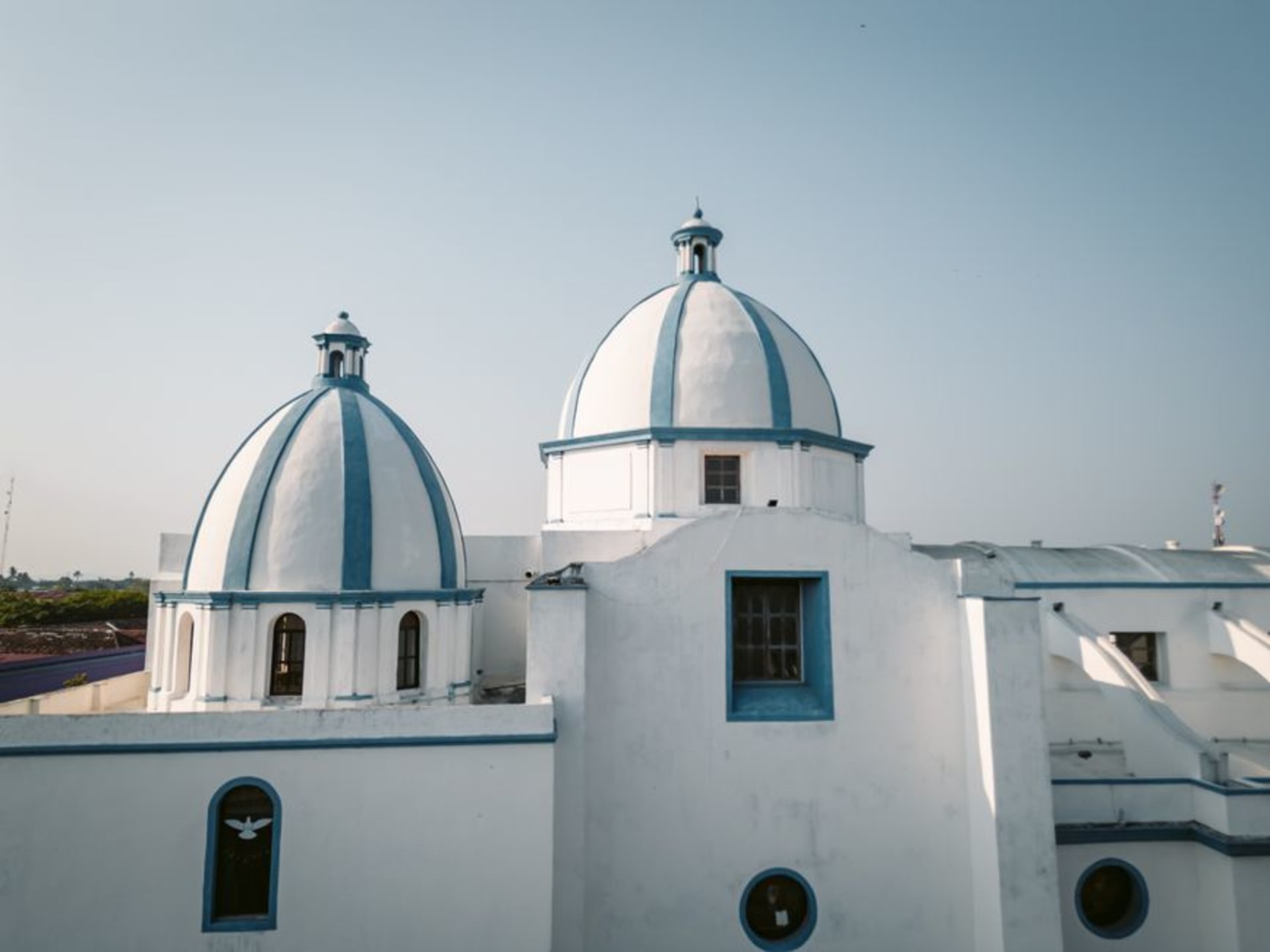 The stone facade of the Ex-Convento de San Andrés Apóstol rises above Aculco's cobbled streets, late-afternoon light warming the colonial arches and atrium walls.