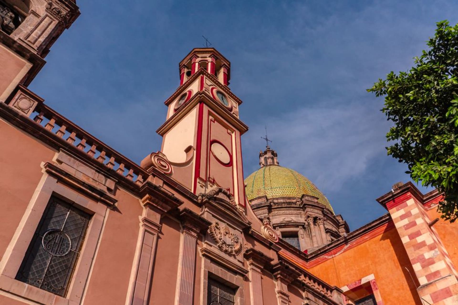 The neoclassical dome of the Templo del Carmen rising above Celaya's colonial center under a pale blue afternoon sky