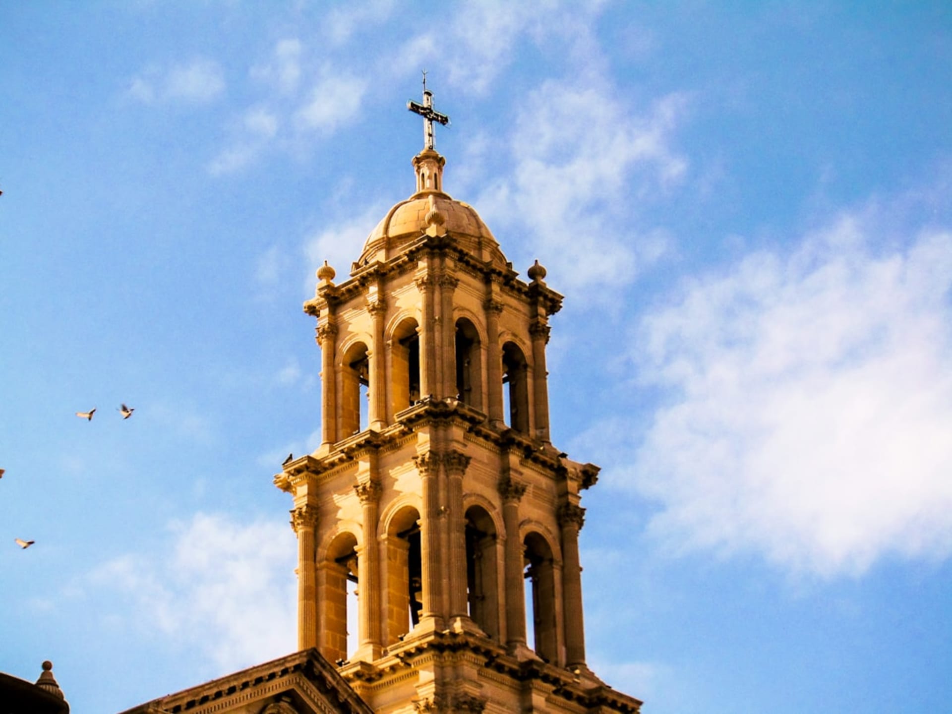 Chihuahua's cathedral on the Plaza de Armas at night, its baroque towers illuminated above the colonial plaza, the wide northern Mexico sky behind with stars beginning to appear at dusk