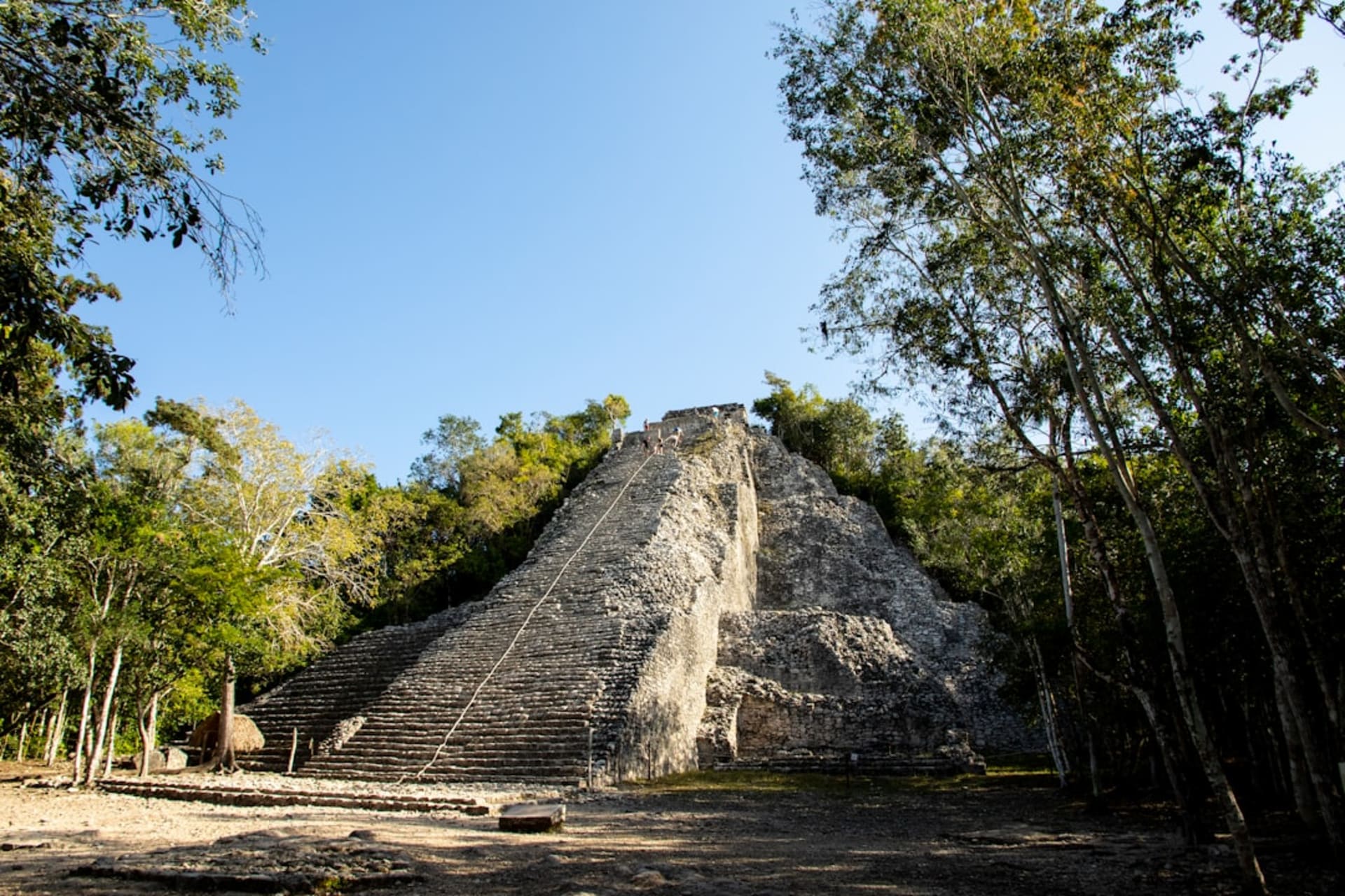 The yellow domes of the Nuestra Señora de los Remedios church perched atop the Great Pyramid of Cholula, with Popocatépetl volcano rising in the distance behind it