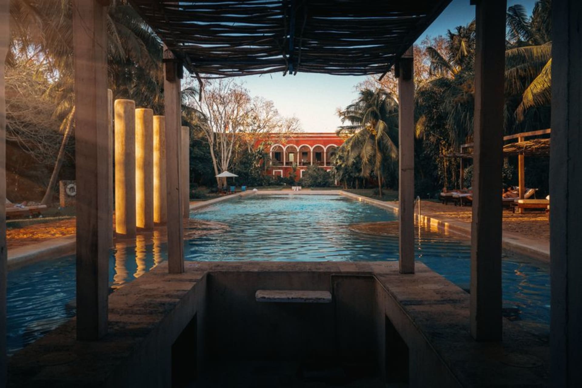 Stone aqueduct arches of Ex-Hacienda de Cocoyoc spanning a reflecting pool surrounded by tropical gardens in Morelos