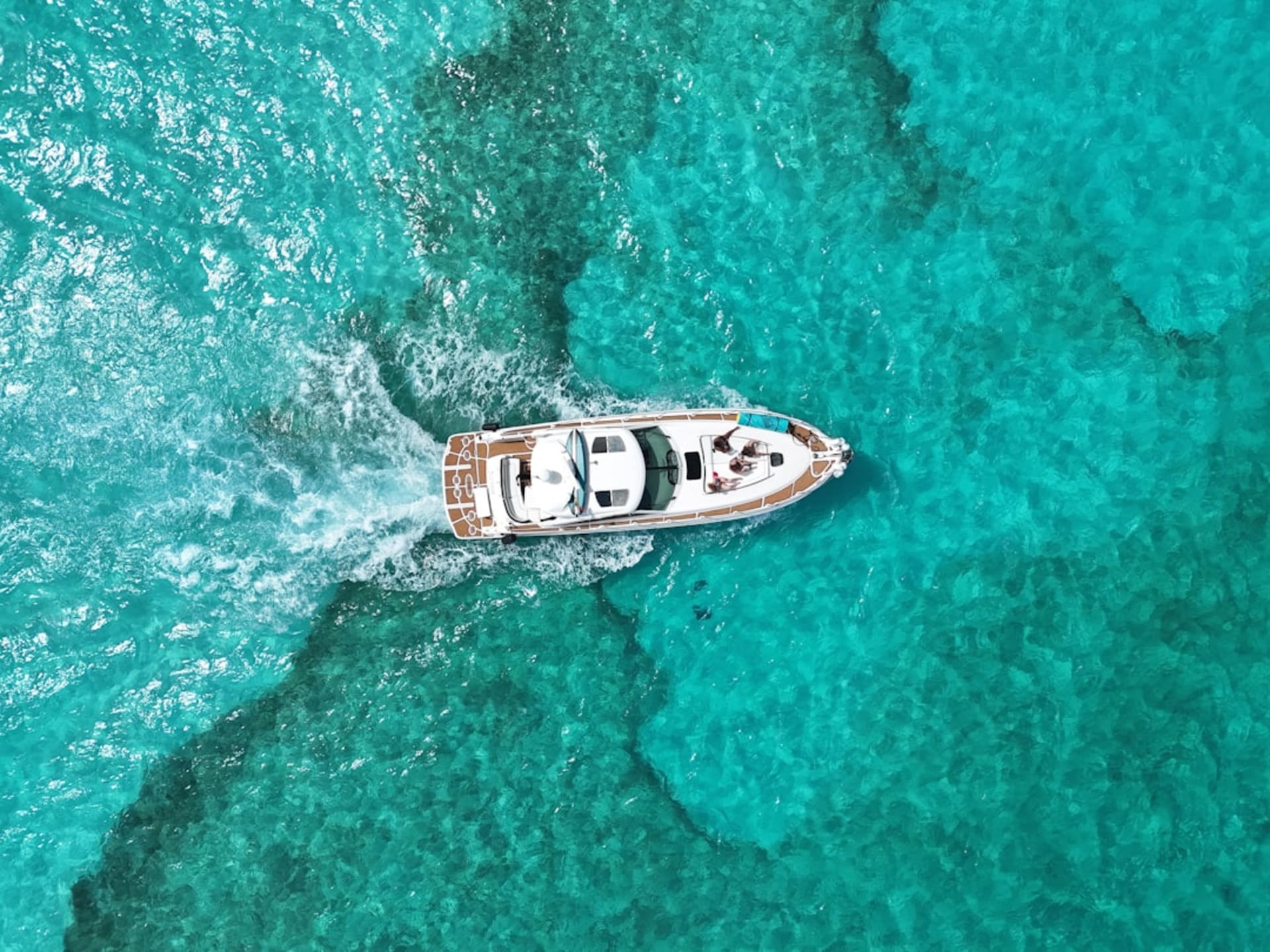 The turquoise Caribbean Sea around Isla Mujeres seen from the cliffs at Punta Sur, a wooden lighthouse on the rocky headland, the colors shifting from turquoise to deep cobalt toward the horizon