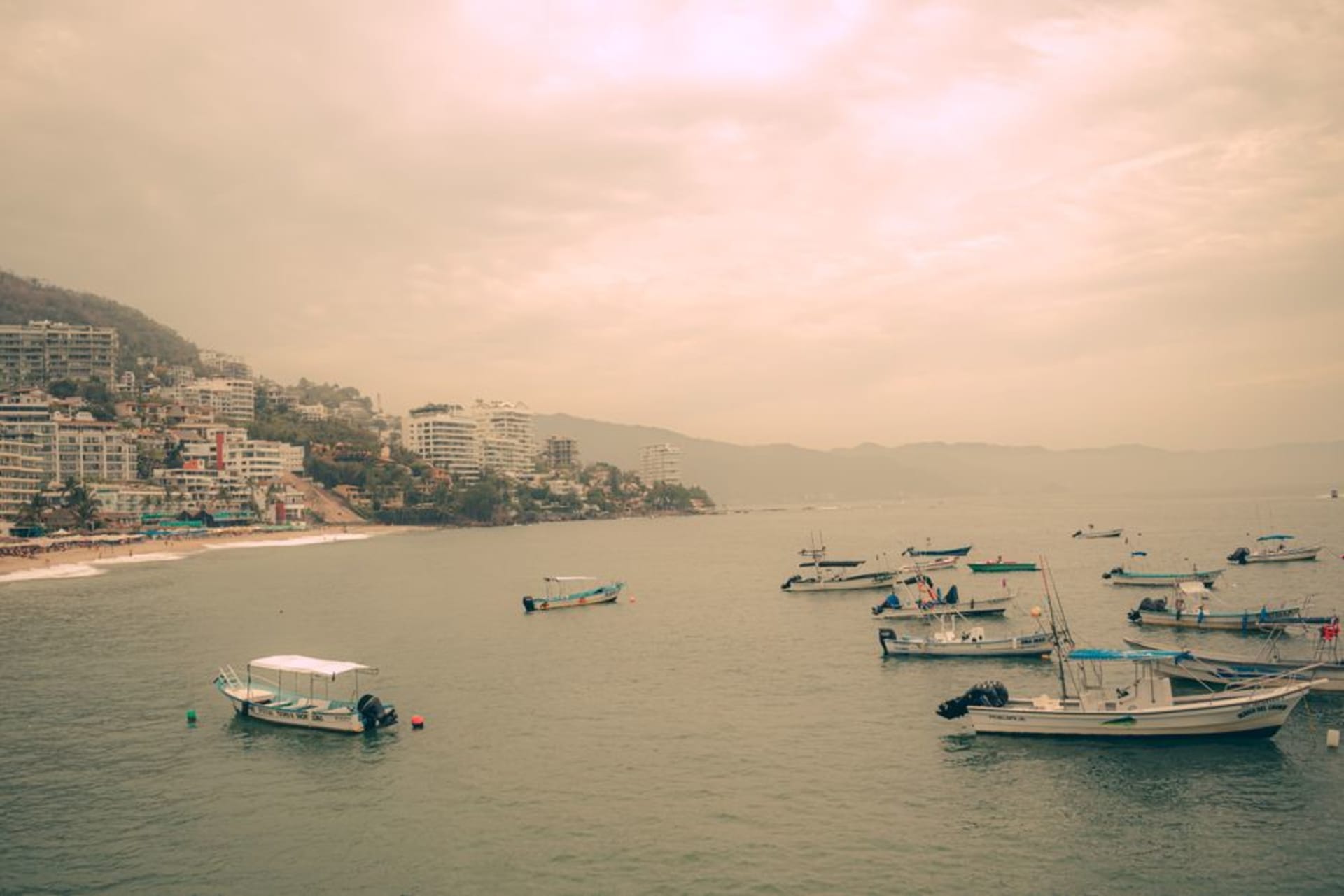 Sailboats anchored in the deep-water marina at La Cruz de Huanacaxtle with the Nayarit hills rising behind at golden hour