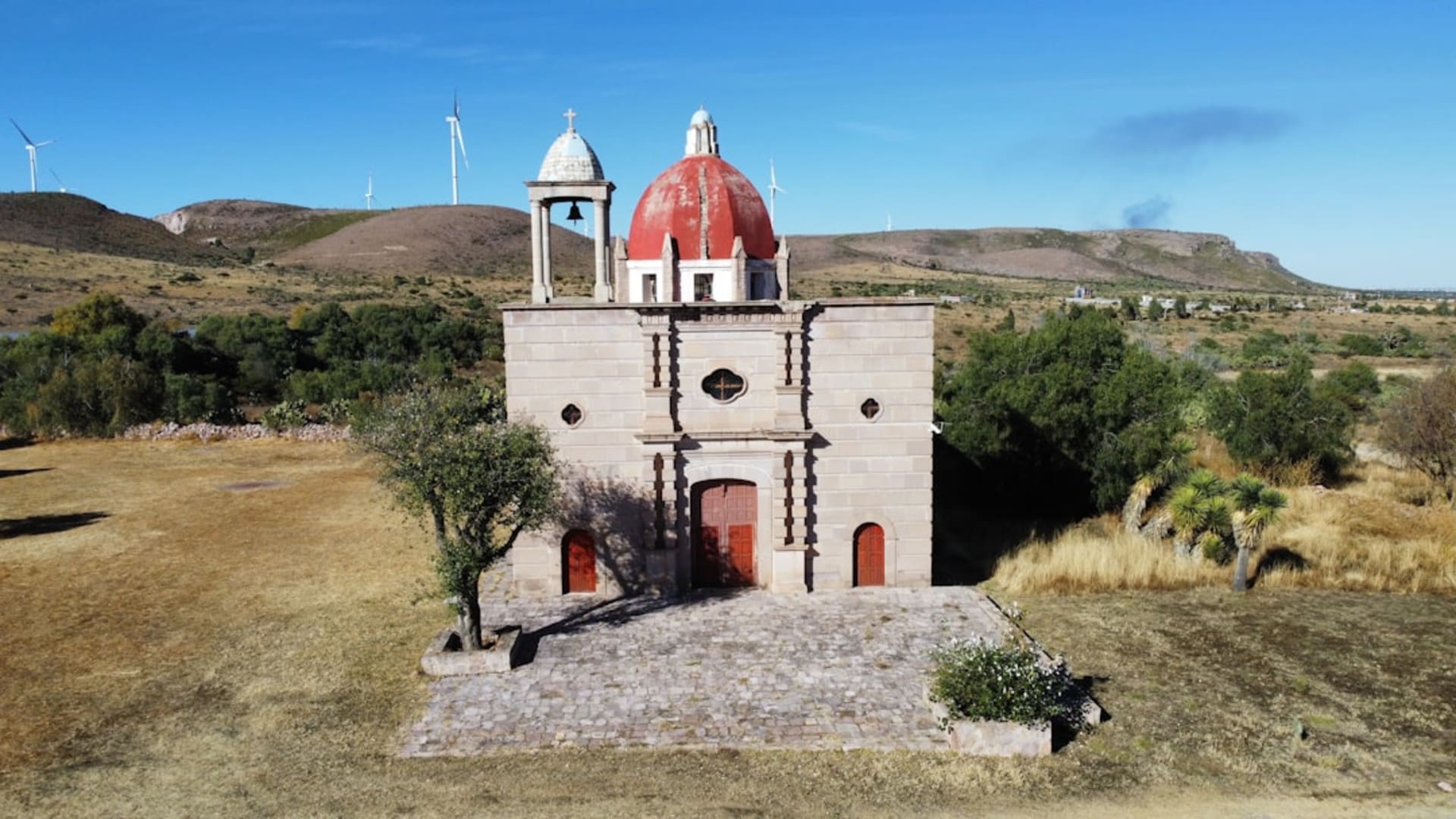 Stone facade of Monte Escobedo's colonial parroquia rising above the main plaza on a cold July afternoon in the pine mountains of southern Zacatecas