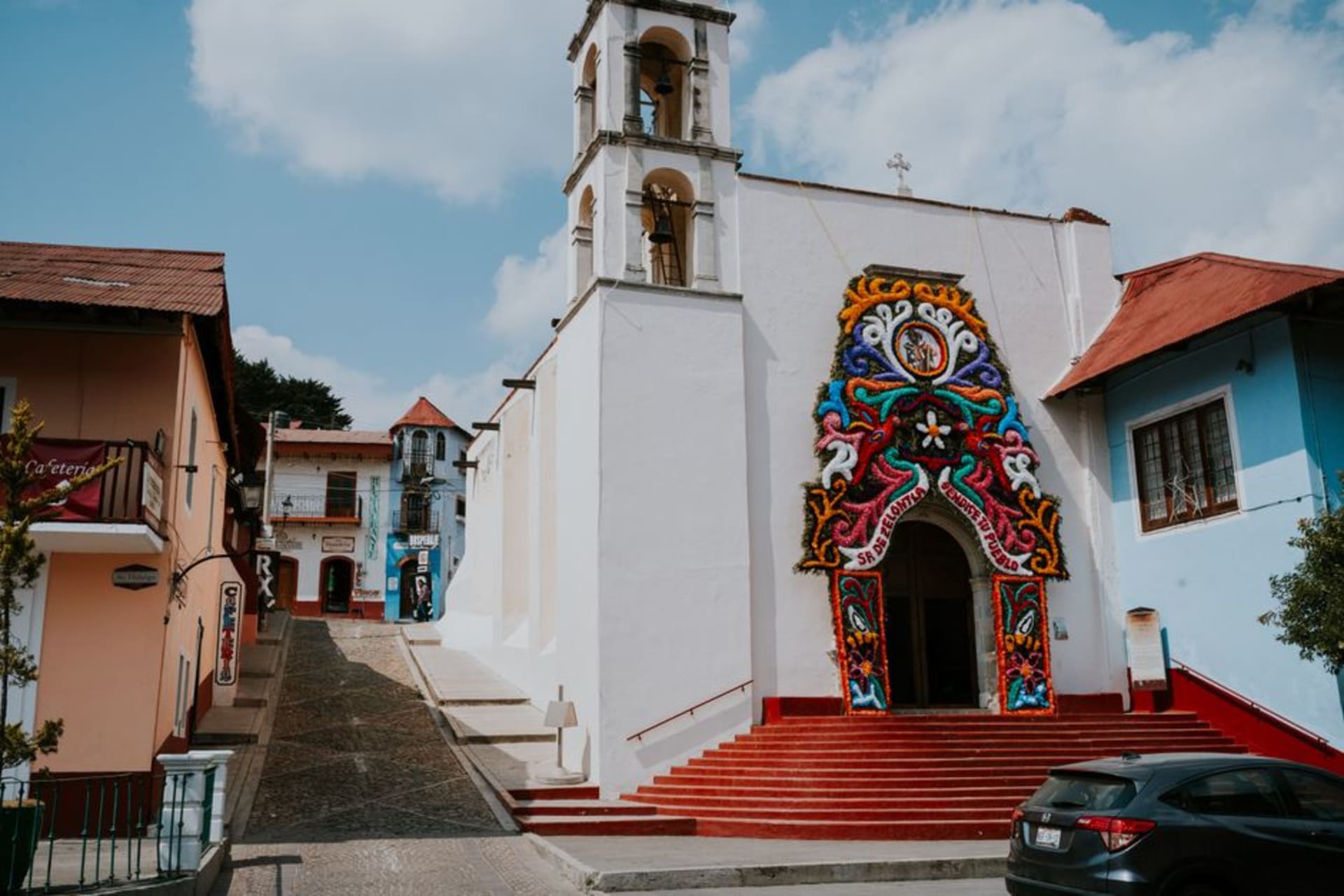 The colonial mining town of Real del Monte in Hidalgo, the cemetery with its characteristic colored tombstones on the hillside, the mining headframes visible above the town, the green highland landscape below