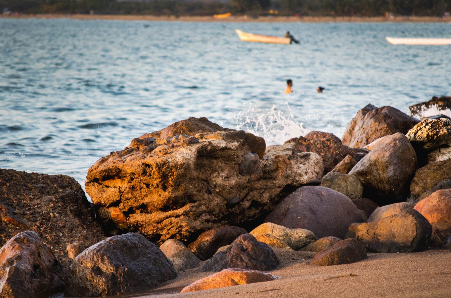 The calm protected bay at Rincón de Guayabitos in the late afternoon, fishing lanchas pulled up on the sand and the Riviera Nayarit coastline curving north in the background