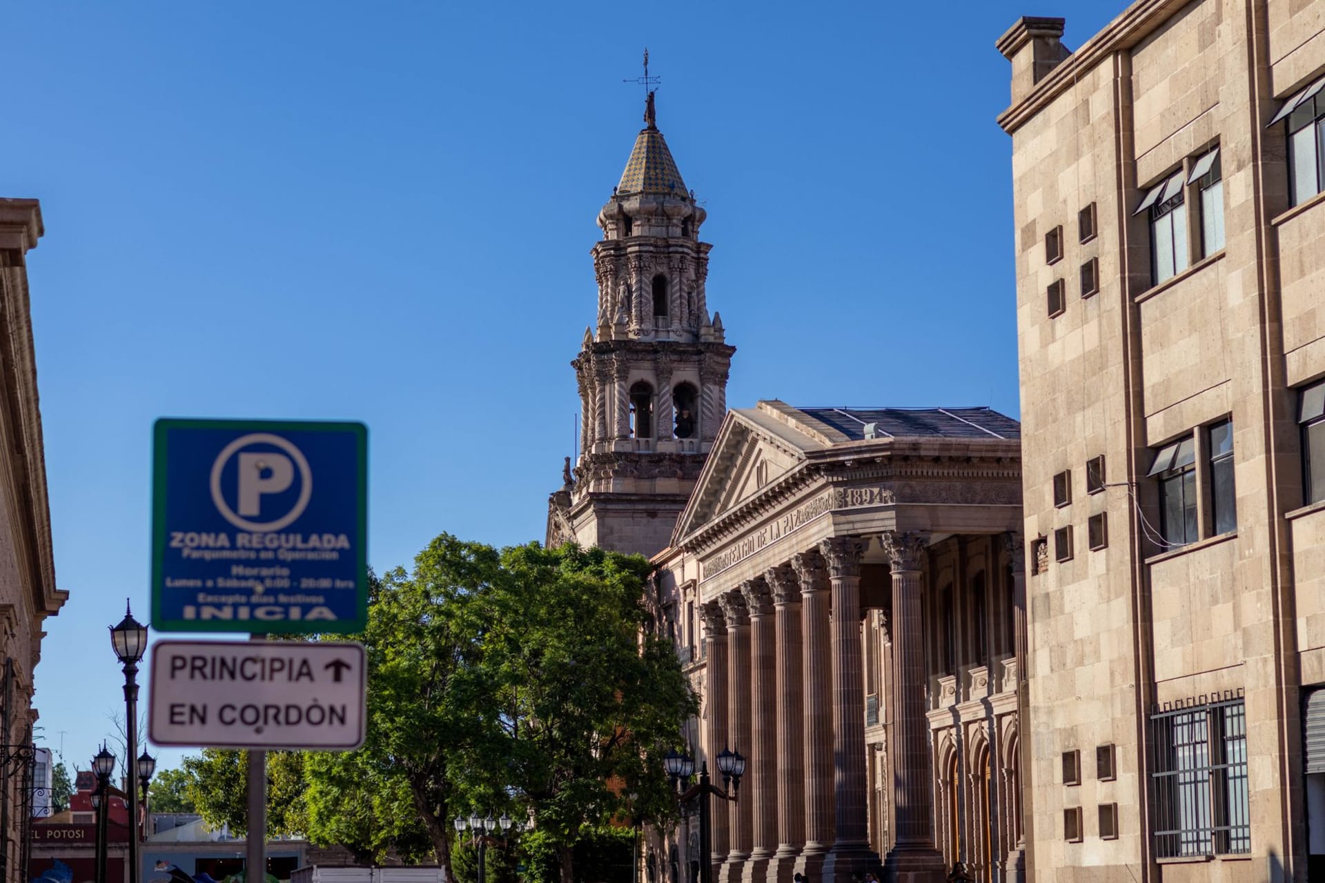 The Teatro de la Paz's Neoclassical facade illuminated at night, the colonnaded entrance reflected in the stone plaza