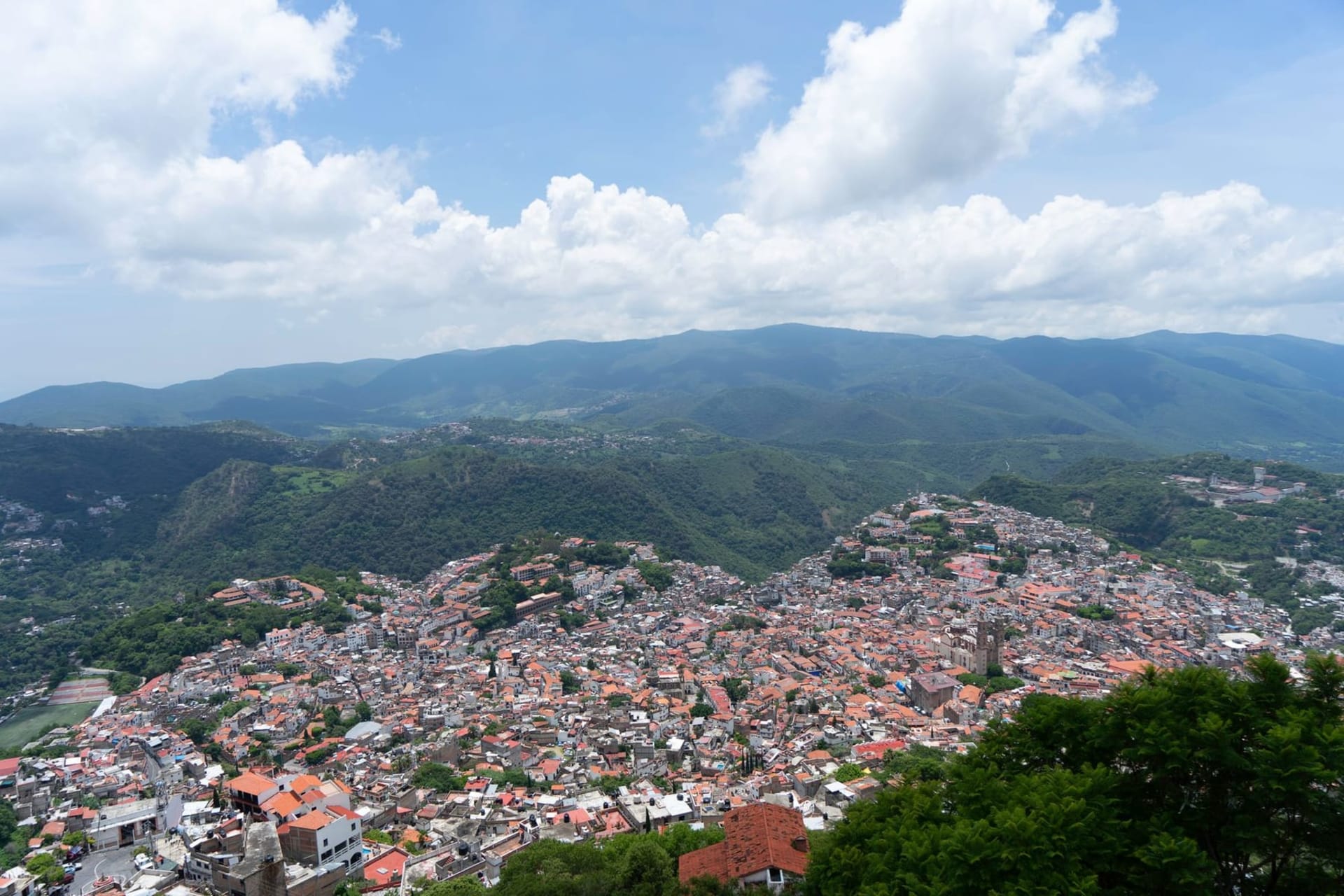 Cobblestone streets winding steeply between whitewashed colonial buildings and silver jewelry shops, with the twin towers of Santa Prisca Cathedral rising above Taxco's terracotta rooftops.