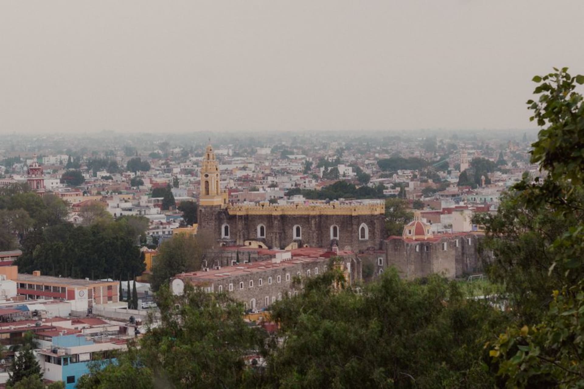 The cylindrical stone Rollo tower rising above Friday market stalls and canvas awnings in Tepeaca, Puebla