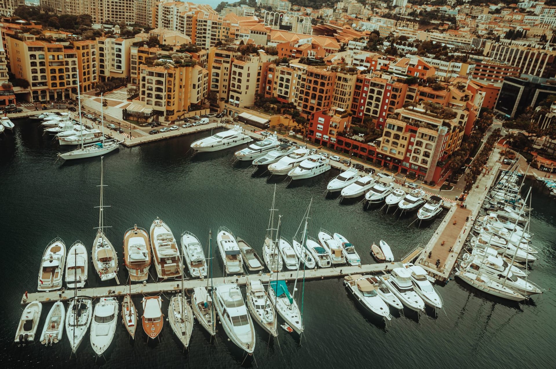 Port Hercule at morning light, superyachts moored in rows with Monaco's terraced hillside rising above