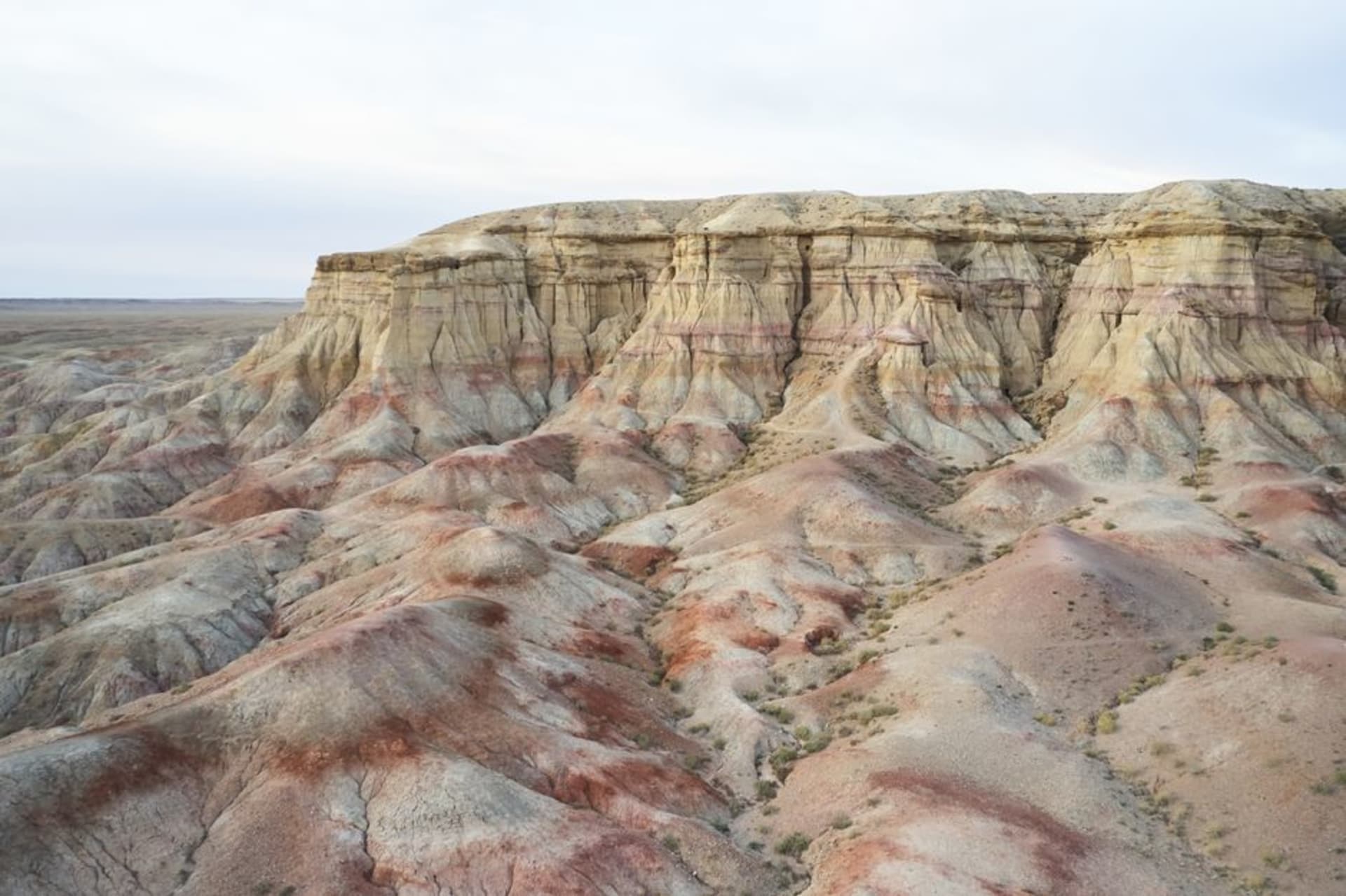 La formation rocheuse de Tsagaan Suvarga, le Stupa Blanc, s'embrasant d'orange au coucher du soleil au-dessus du sol plat du désert de Gobi