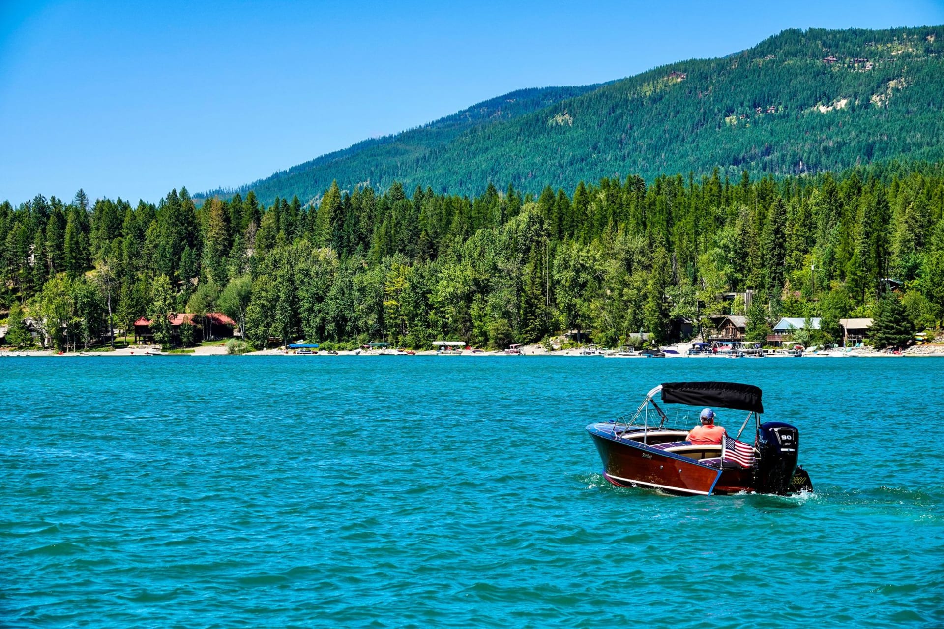 Le lac Flathead vu d'en haut à l'heure dorée, la vaste eau bleue reflétant les monts Mission sur sa rive est
