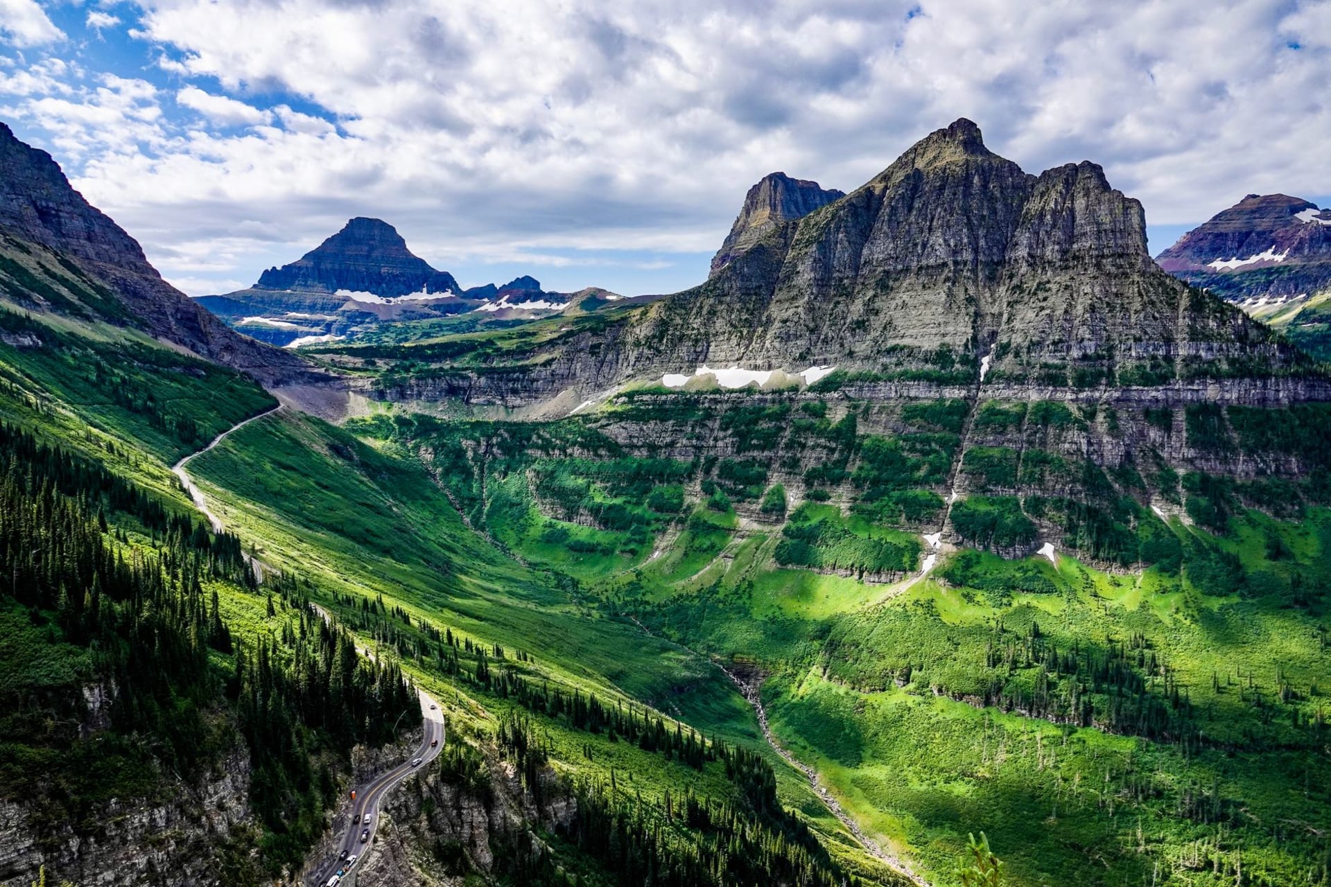 Mountains and valley viewed from above in Glacier National Park, Montana under a wide blue sky