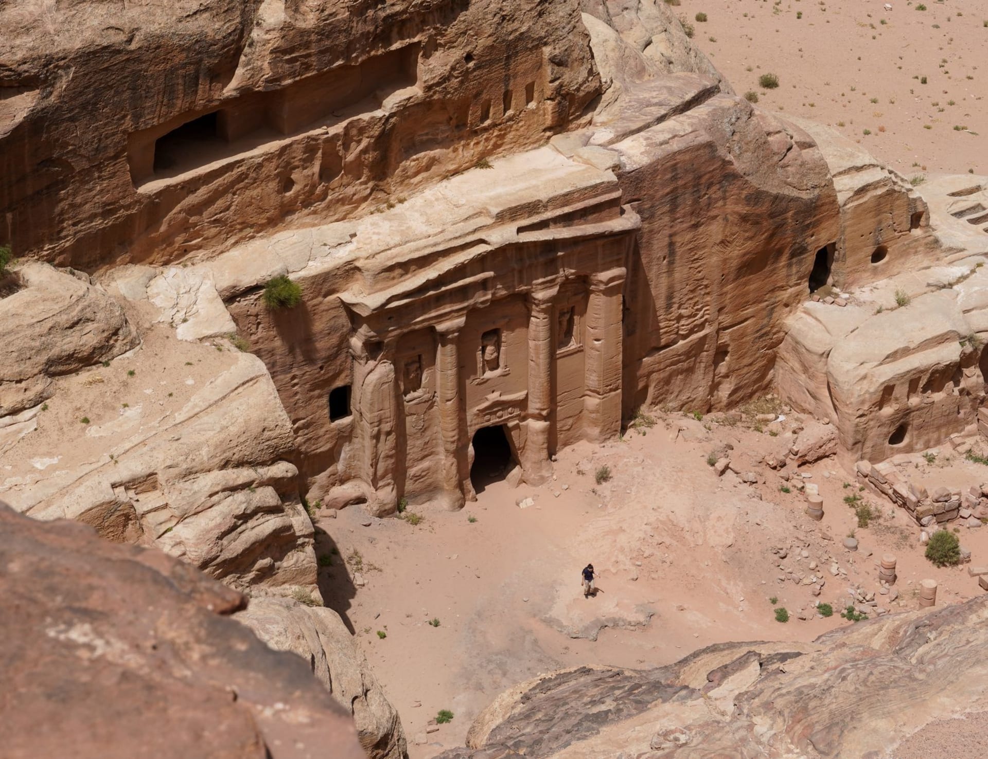 The hillside town of Wadi Musa at dusk, lights coming on in houses terraced up the desert slope above the valley floor
