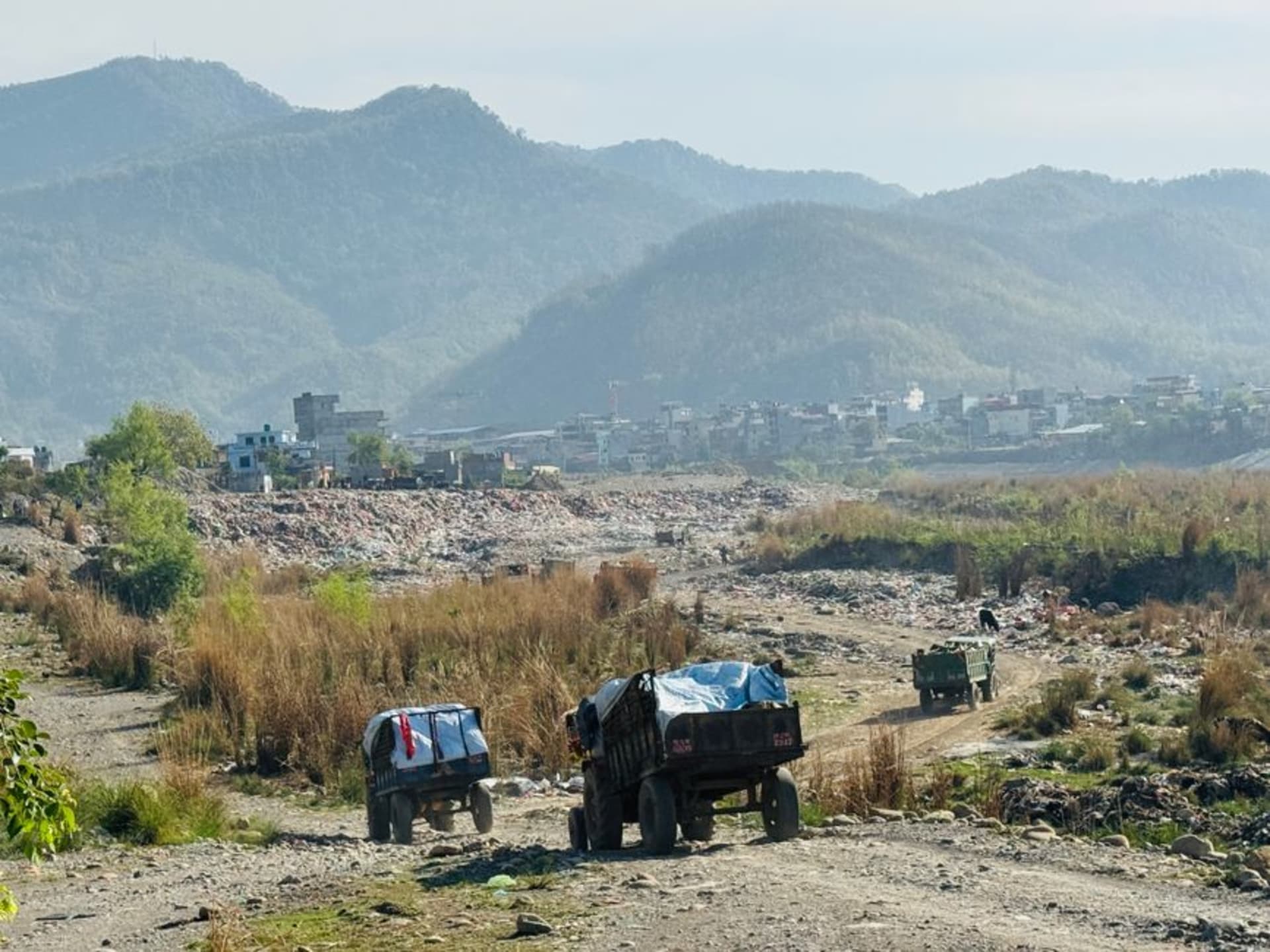 The Tinau River flowing through a rocky gorge on the edge of Butwal, with the city's hillside neighborhoods visible above