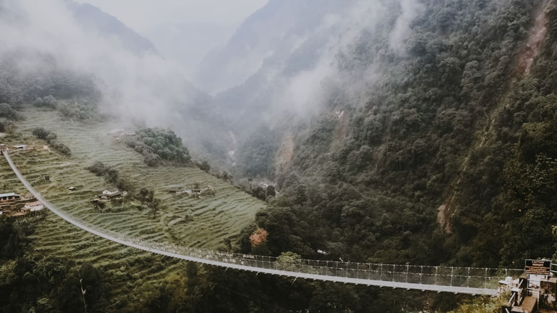 Casas de piedra con tejados de pizarra de Ghandruk escalonadas en una ladera verde, con el Annapurna Sur elevándose justo detrás