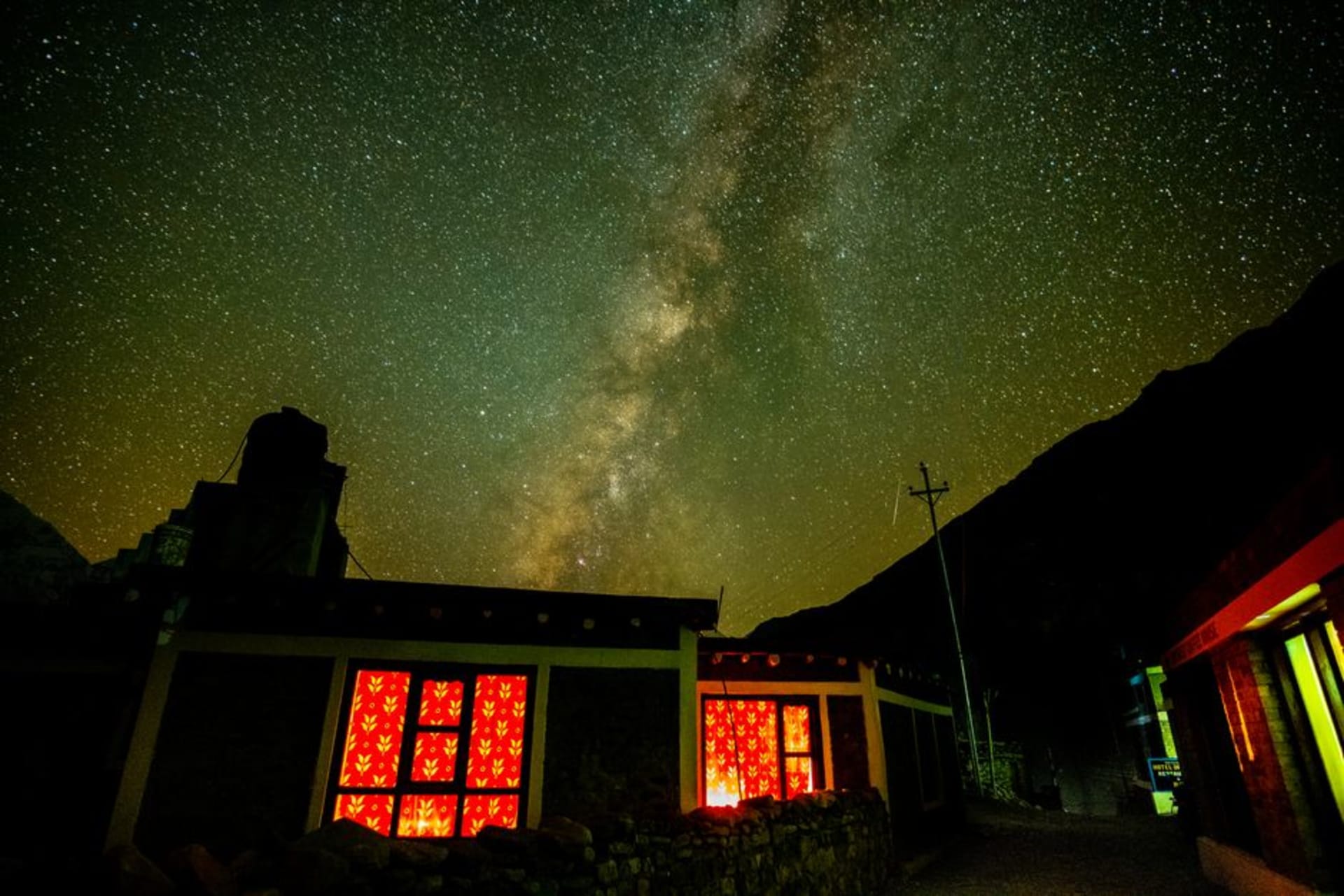 Estrechos callejones encalados del pueblo de Kagbeni con un gompa rojo y un chorten enmarcados contra los acantilados áridos de la garganta del Kali Gandaki