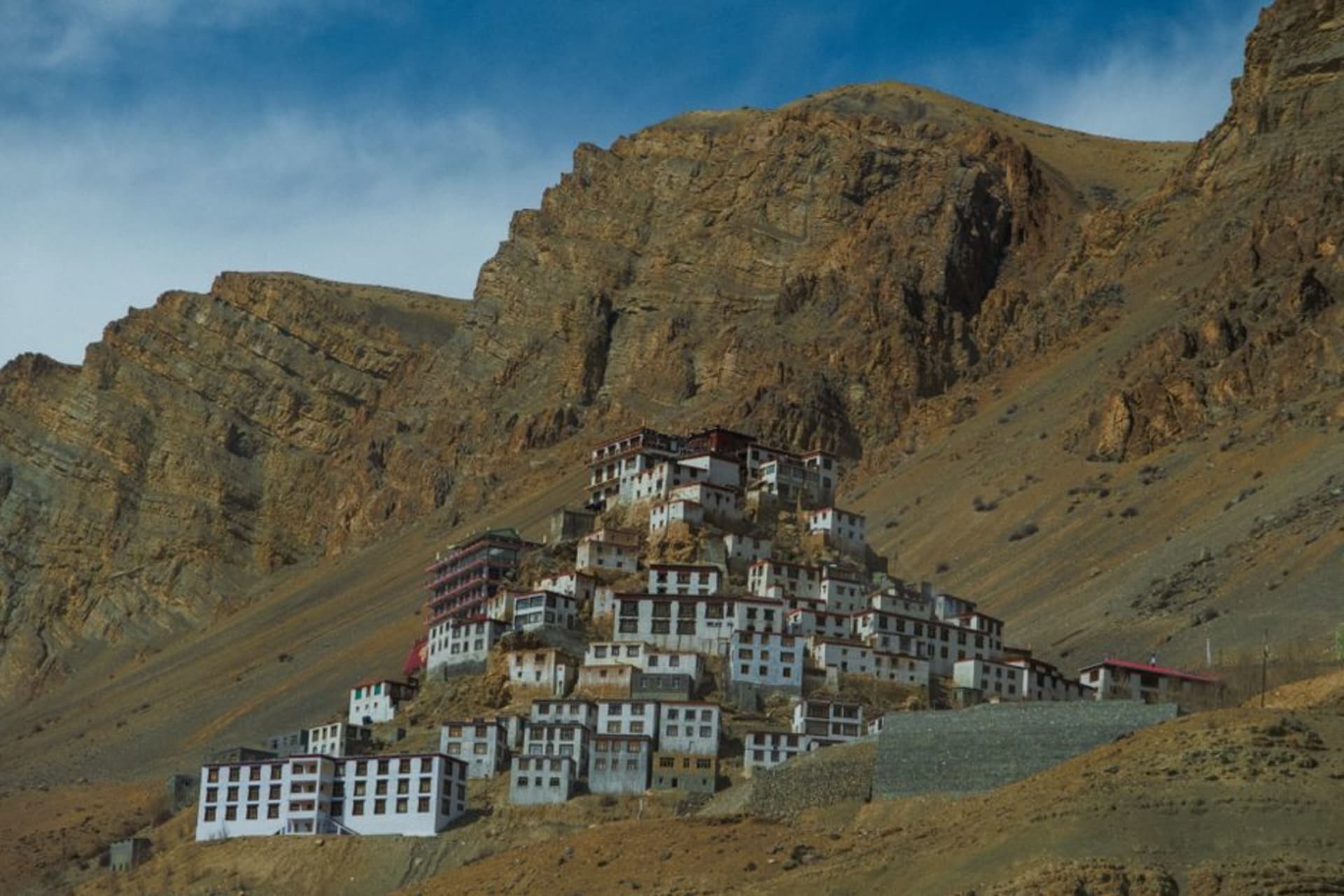 Ancient cave monastery entrance built into a sheer cliff face above Yara village in a remote side valley of Upper Mustang