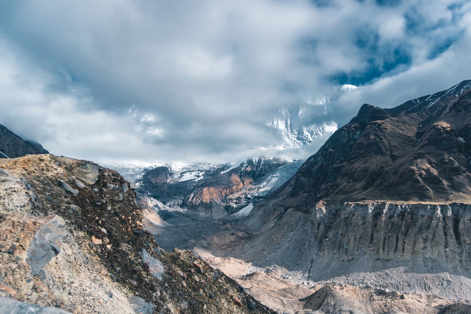 Sweeping panoramic view of the Annapurna massif with snow-covered peaks rising above a high-altitude glacial basin in the Nepal Himalayas