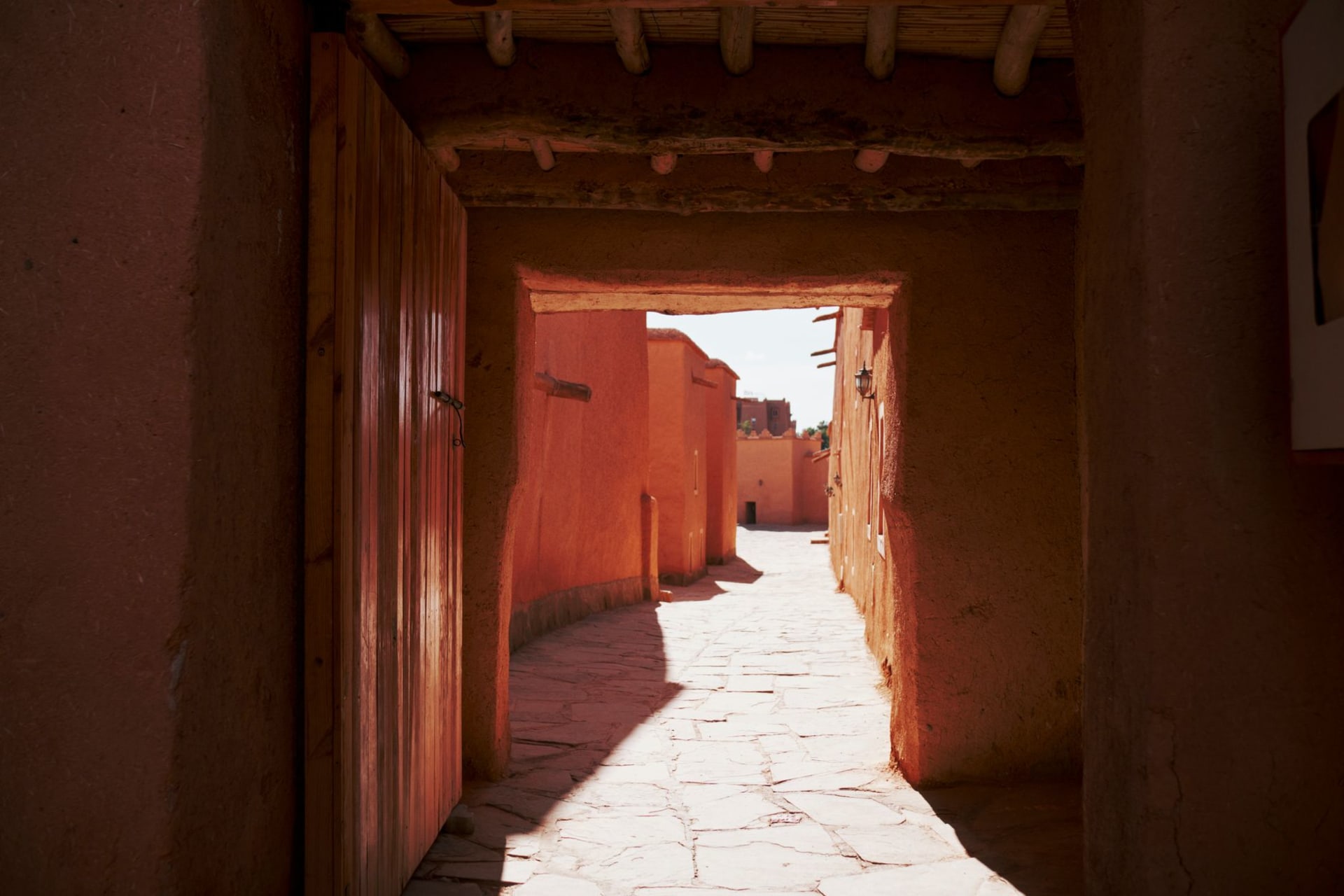 Murs en adobe à plusieurs étages de Taos Pueblo s'élevant dans des tons d'ocre chaud sous un ciel bleu clair, avec des montagnes derrière