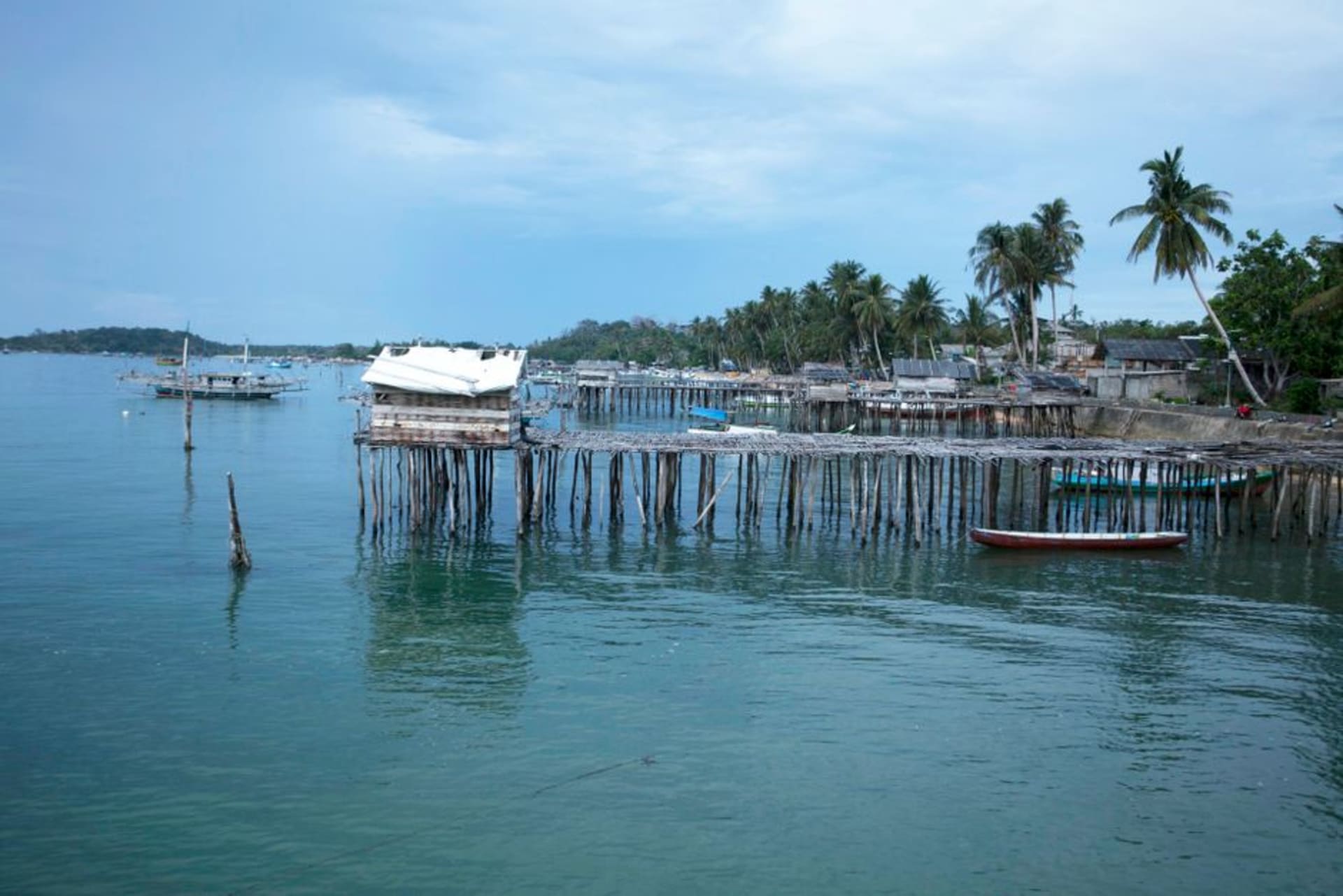 Wooden houses on stilts along the waterfront of Bluefields at golden hour