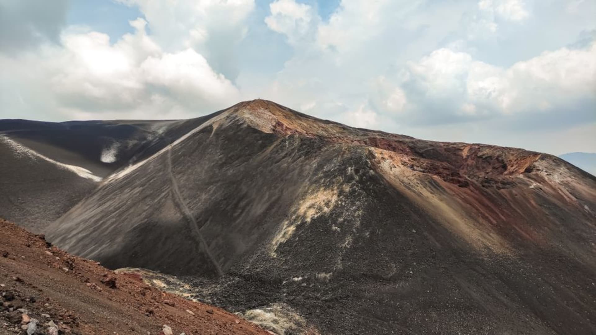 Hikers approaching the steep summit ridge of El Hoyo volcano near León