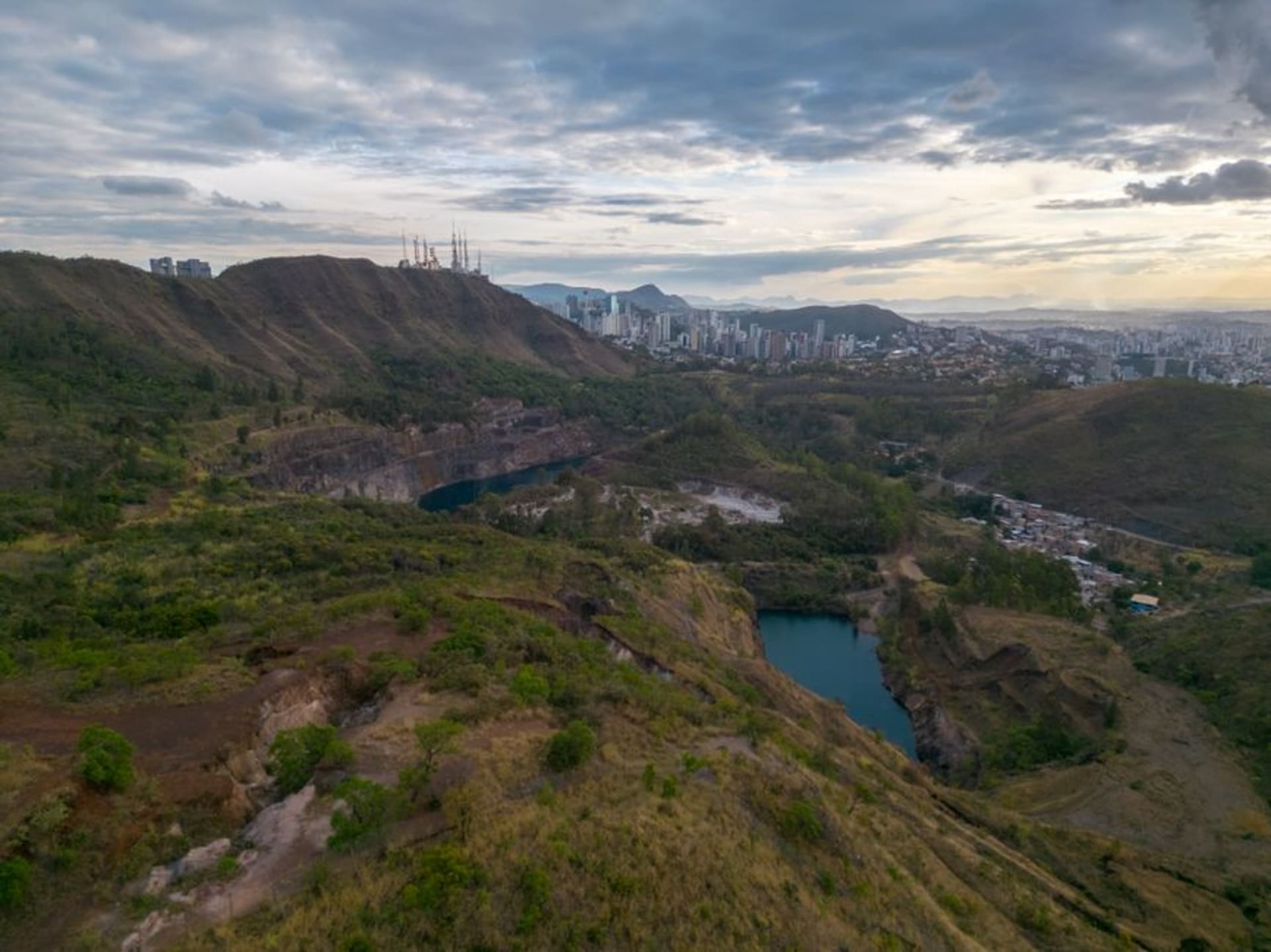Laguna de Tiscapa crater lagoon in the middle of Managua at dusk, with the black silhouette monument of Augusto Sandino visible on the ridge above