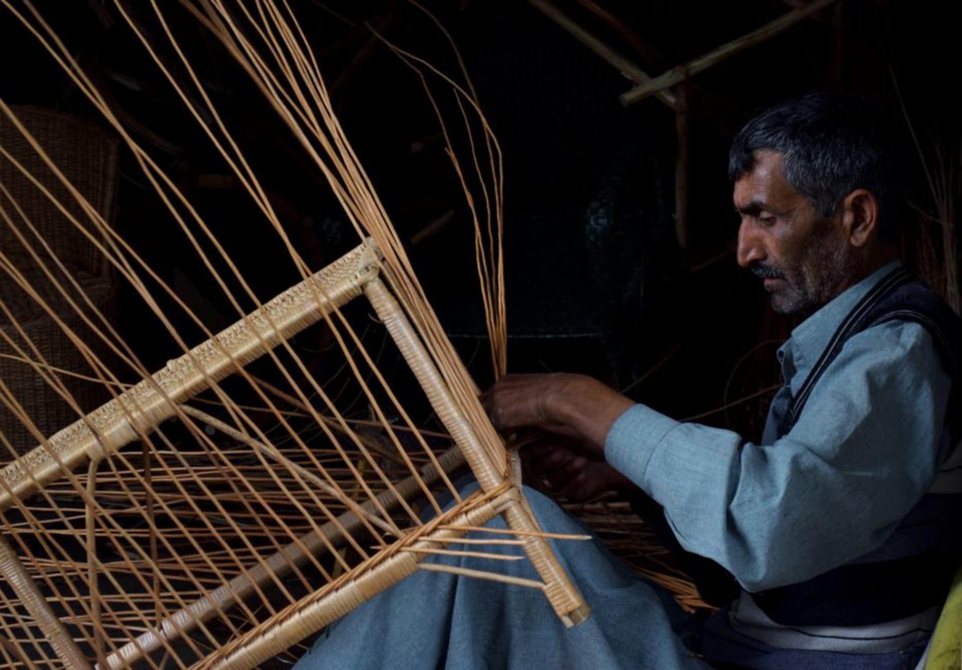 Handmade wicker rocking chairs lined up outside a workshop in Masatepe