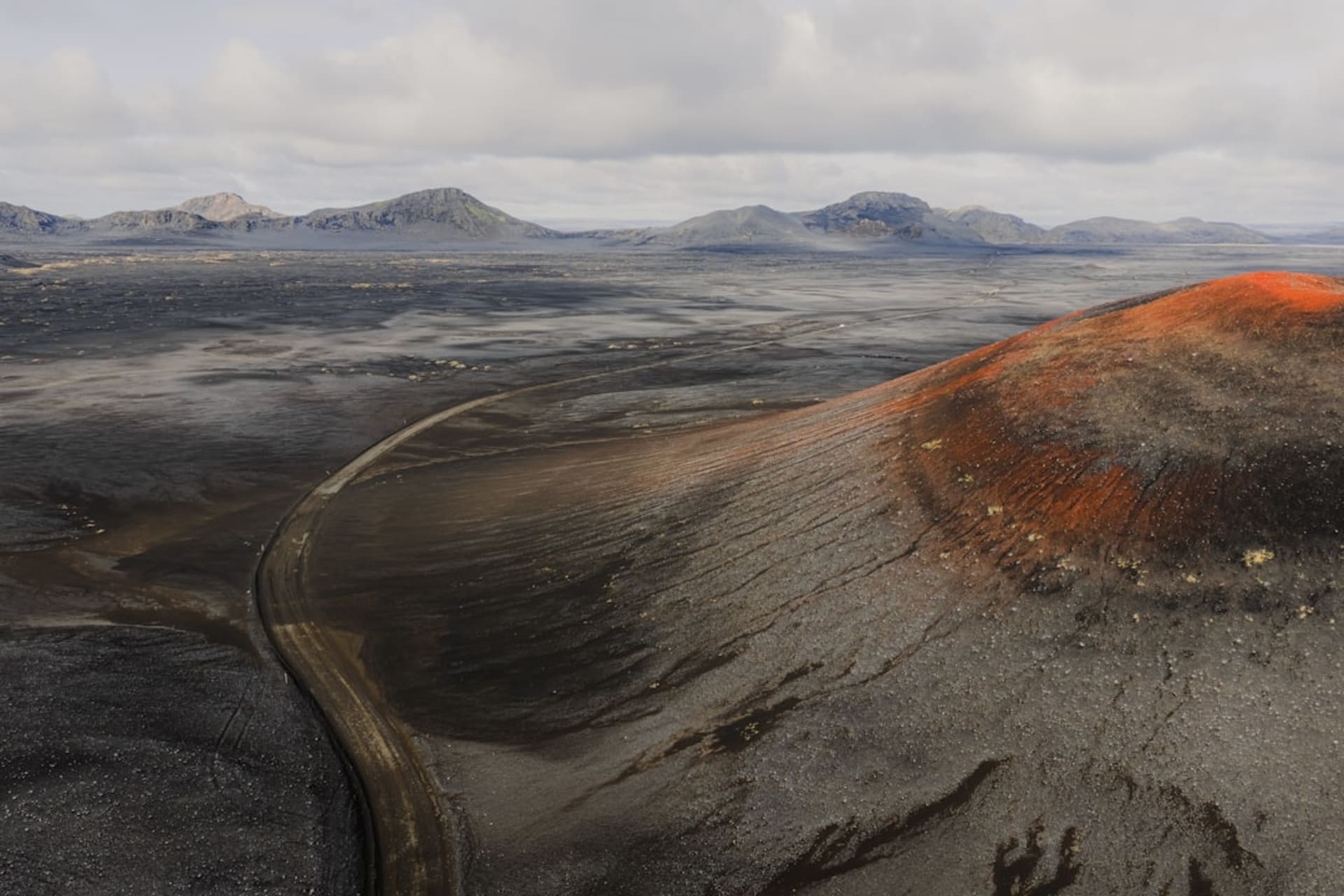 Glowing orange lava visible deep within the active crater of Masaya Volcano at night, sulfurous smoke rising from the vent
