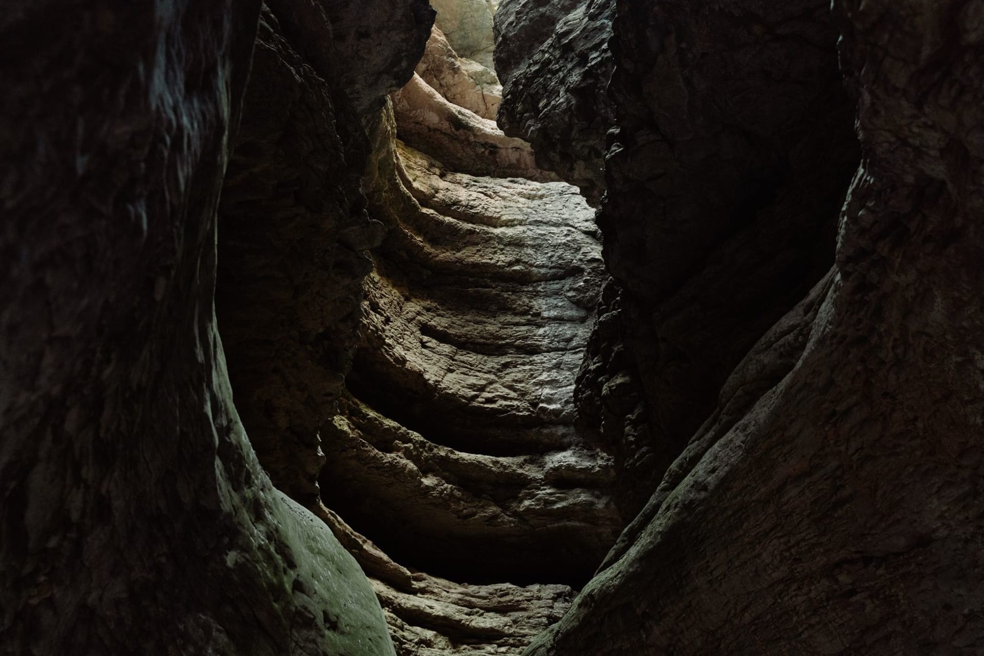 The towering coral limestone walls of Togo Chasm with shafts of light falling into the pool below
