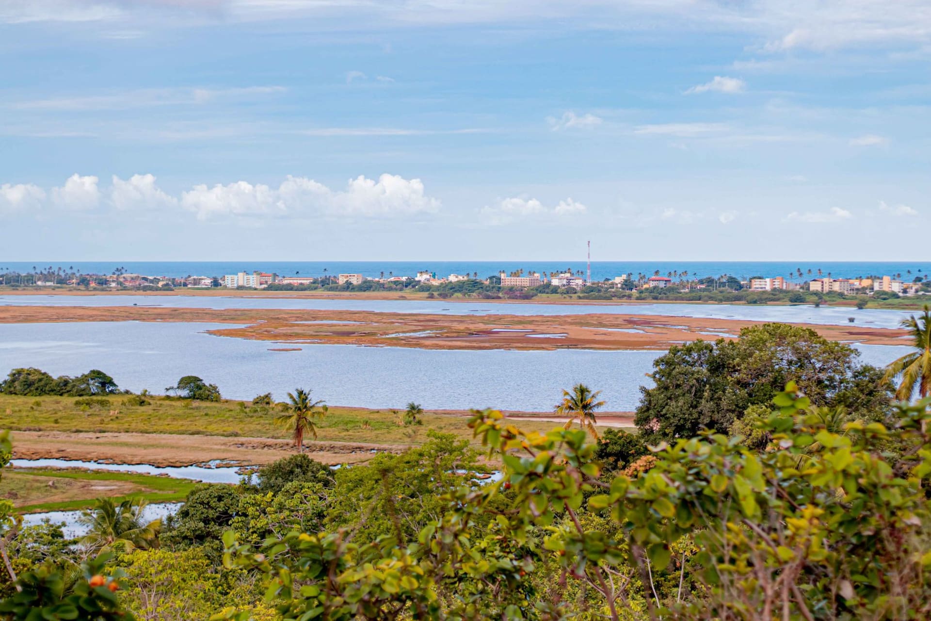 Clear turquoise natural tide pools over reef at Porto de Galinhas with wooden jangada rafts floating on calm water