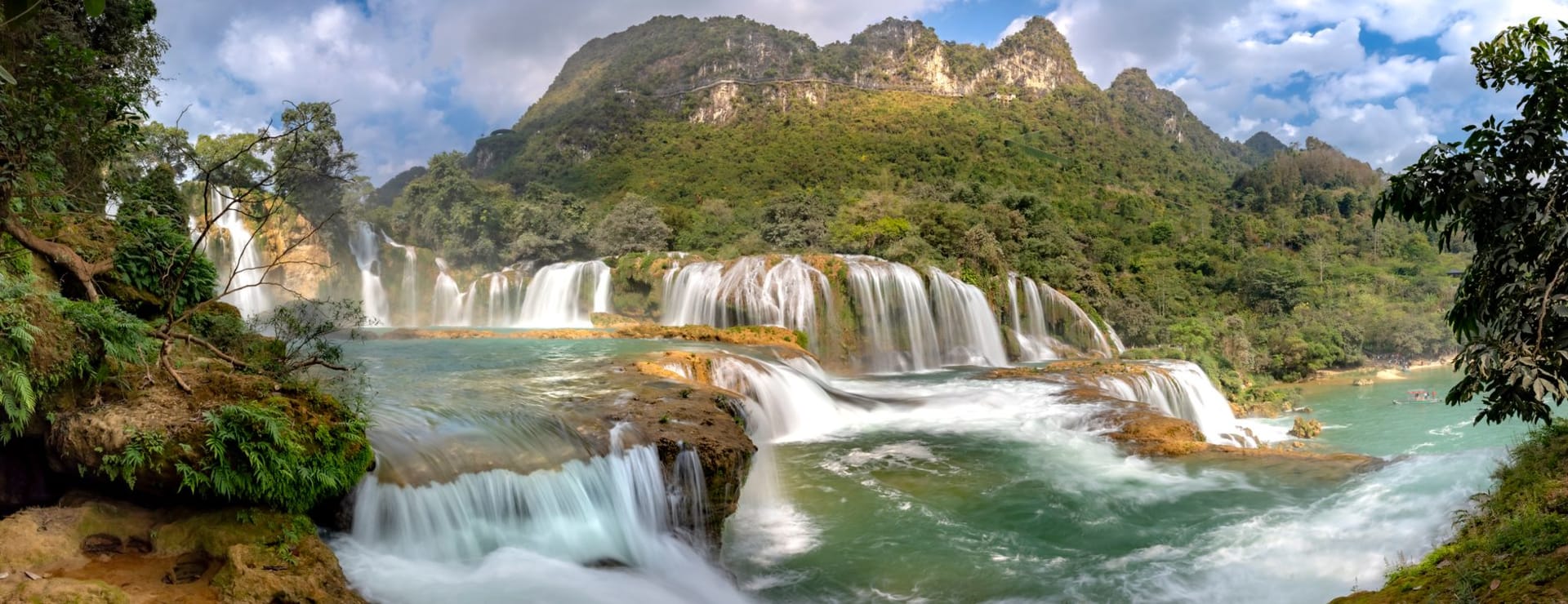 Cao Bằng town in the valley at golden hour, limestone karst hills rising on three sides, the Bằng Giang River catching late light