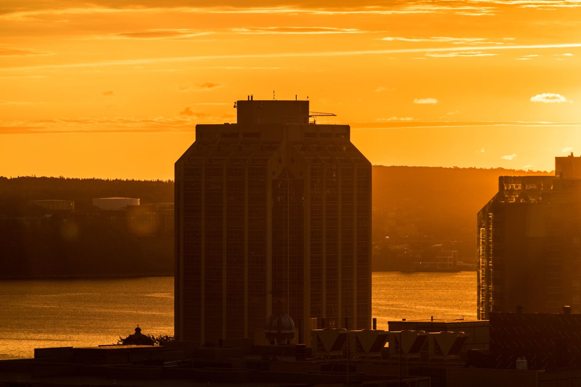 Halifax waterfront with historic wooden wharves and the Angus L. Macdonald Bridge in the background at golden hour