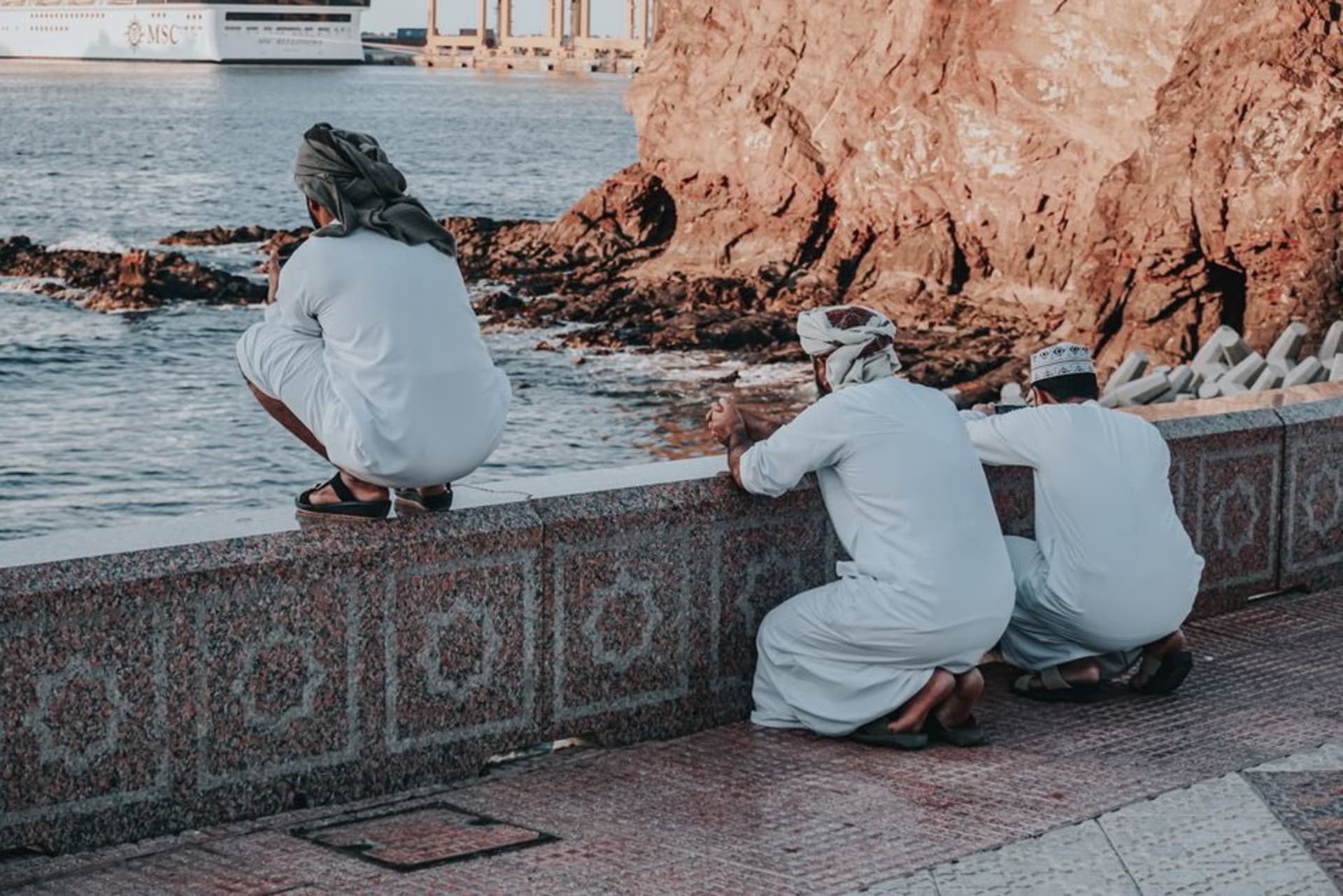 Dhows tradicionales de madera alineados en la playa de Dibba con las montañas Hajar elevándose detrás, Musandam, Omán