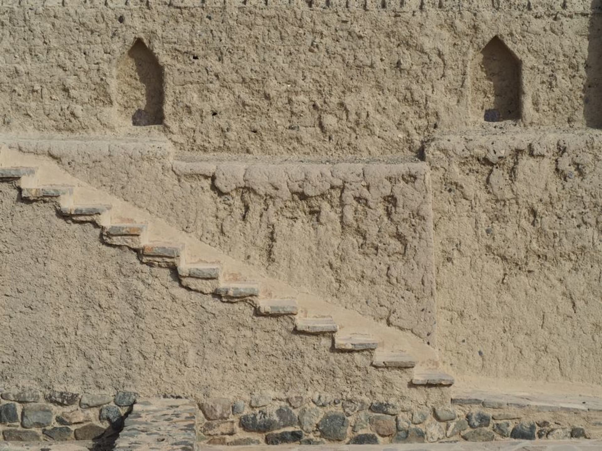 Les tours en calcaire pâle du château de Jabrin se dressant seules contre la plaine caillouteuse près de Bahla, Oman
