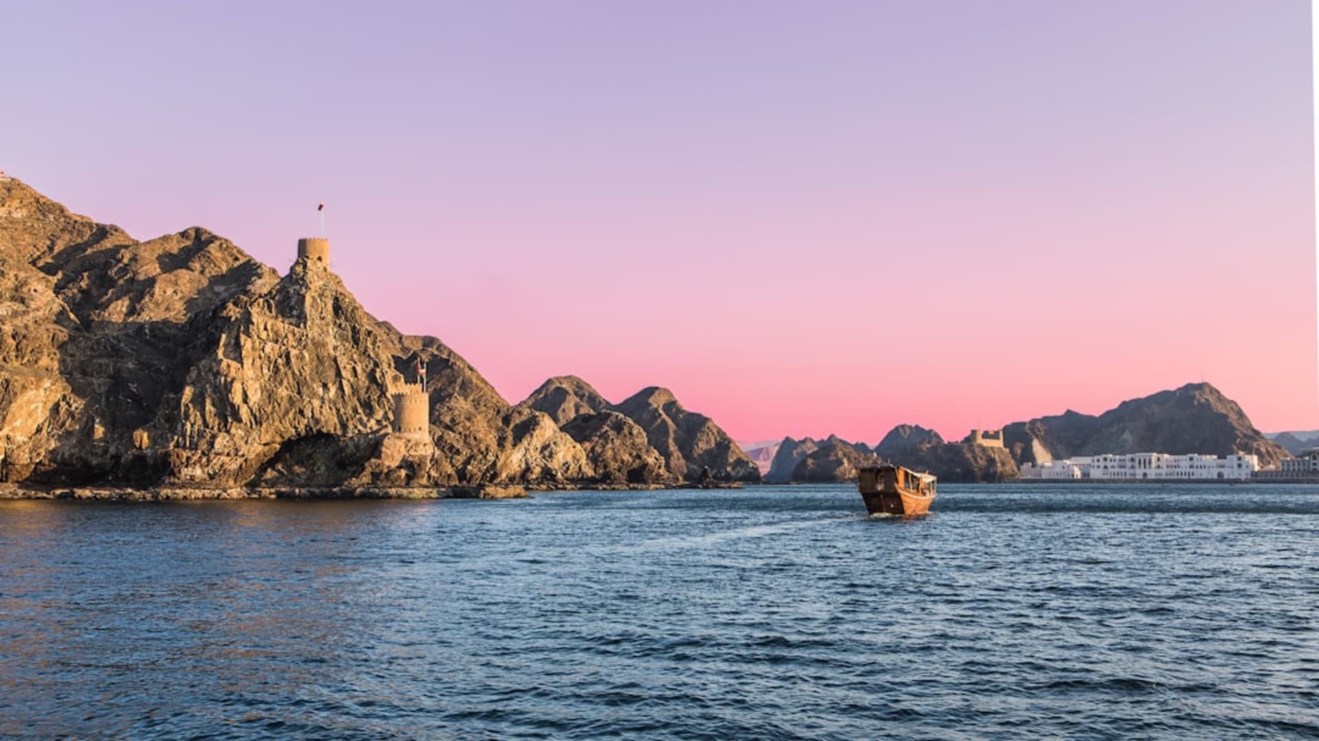 Saham's fishing harbor at dawn with wooden boats lined up and fishermen unloading crates of fish